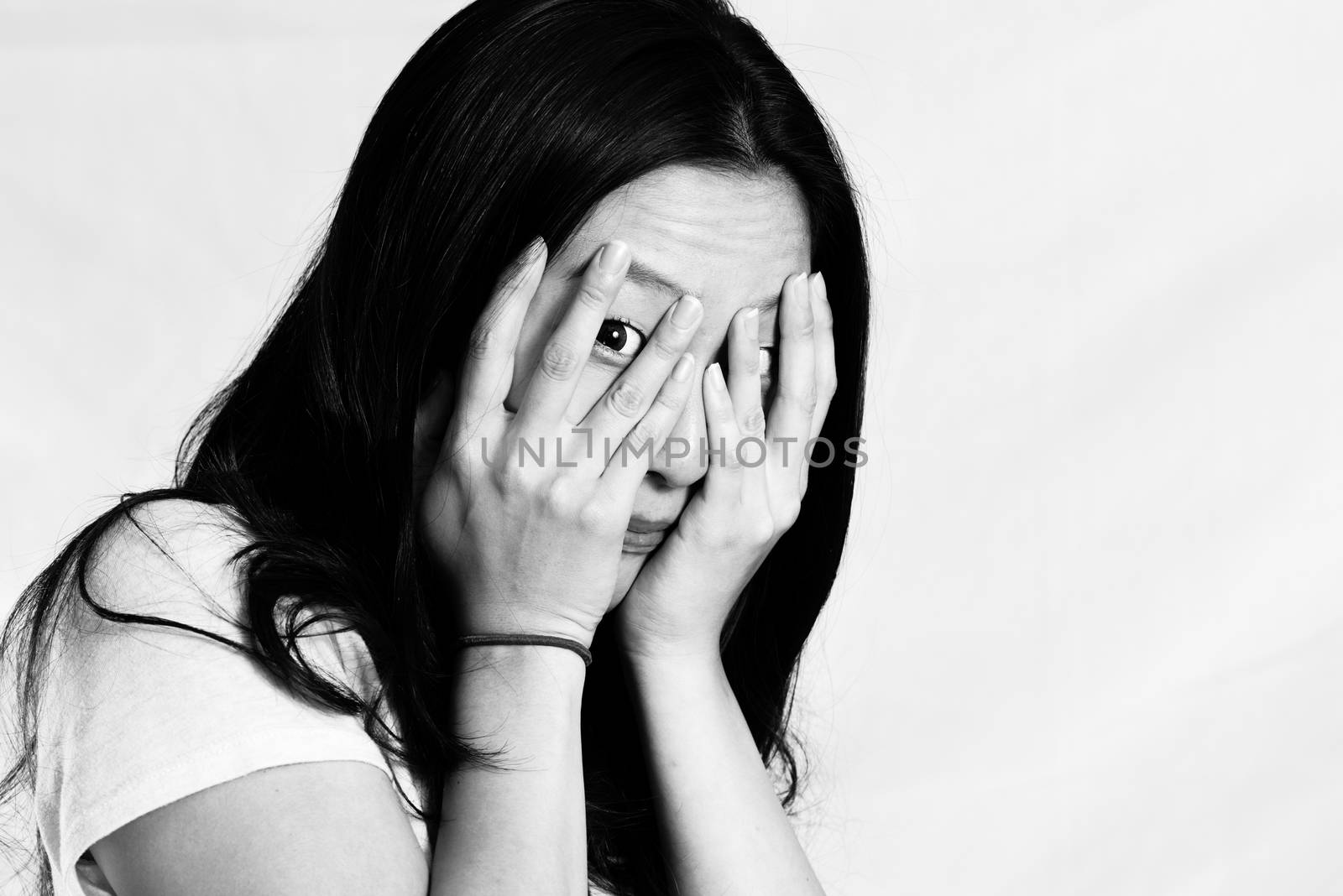 Portrait of cute young woman covering her face, black and white style