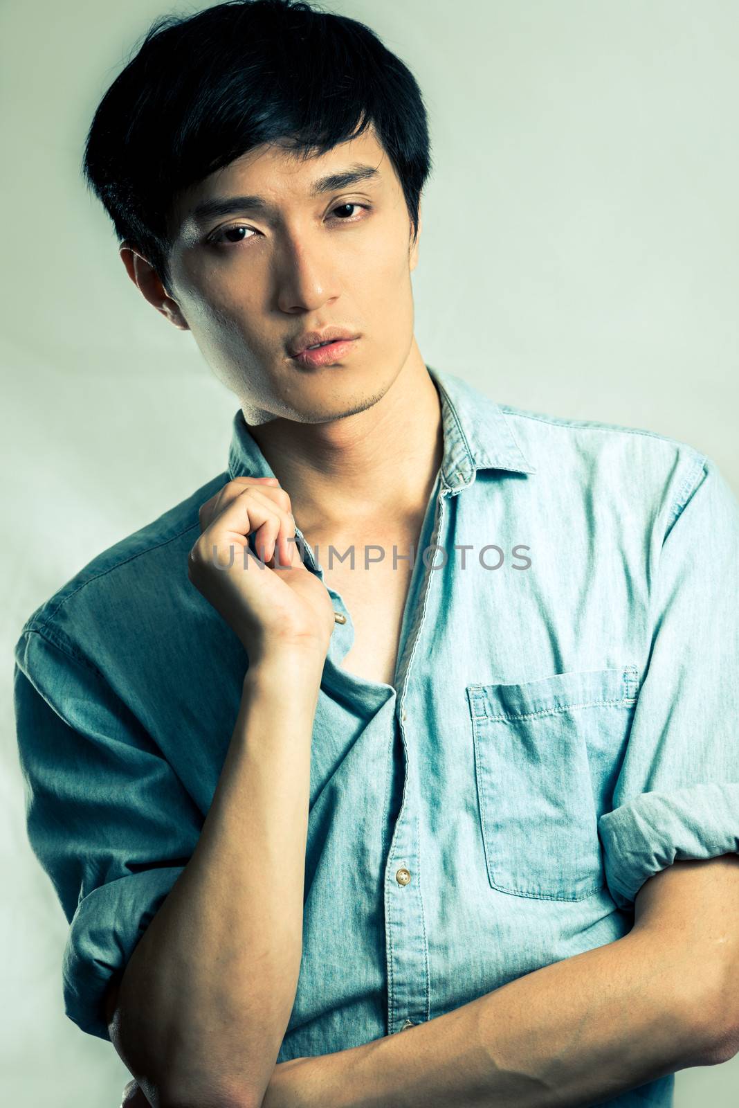 Studio fashion pose by a handsome young male model, with fashion tone and background
