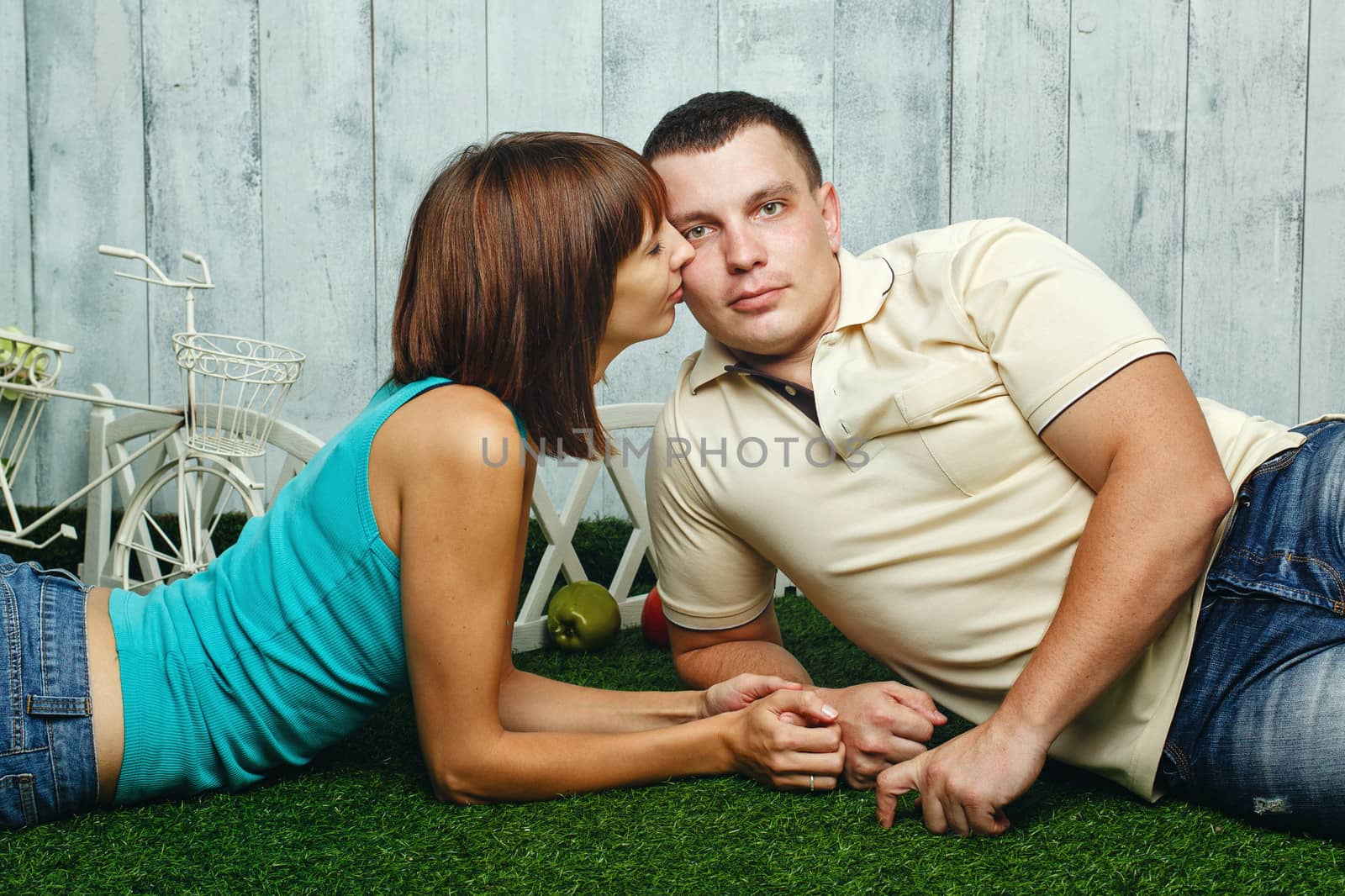 Young, happy married couple relaxing on the lawn and enjoys
