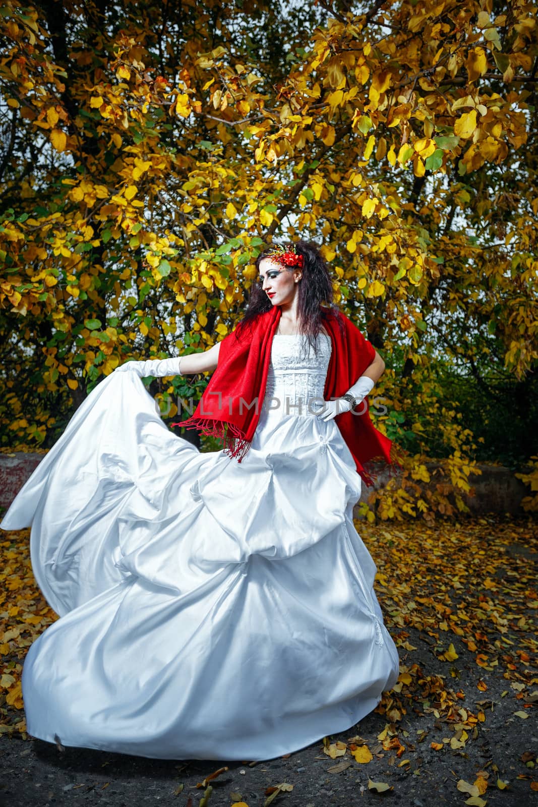 Attractive bride in a wedding dress with bright makeup, red shawl