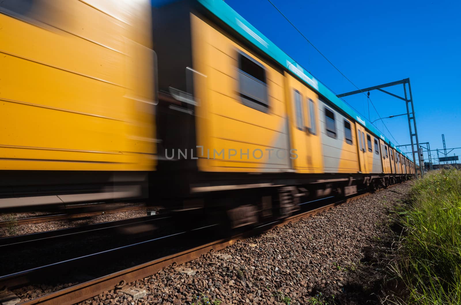 Passenger train speed blurs past in colors outdoors