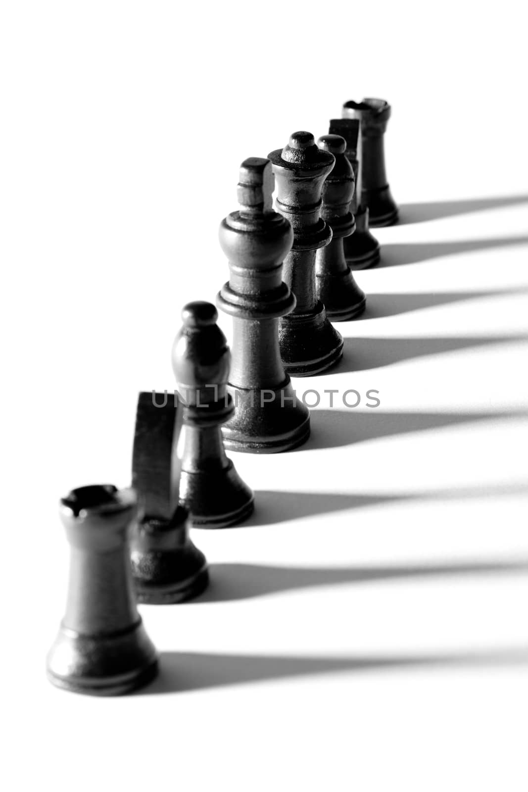 Line of black chess pieces with shadow