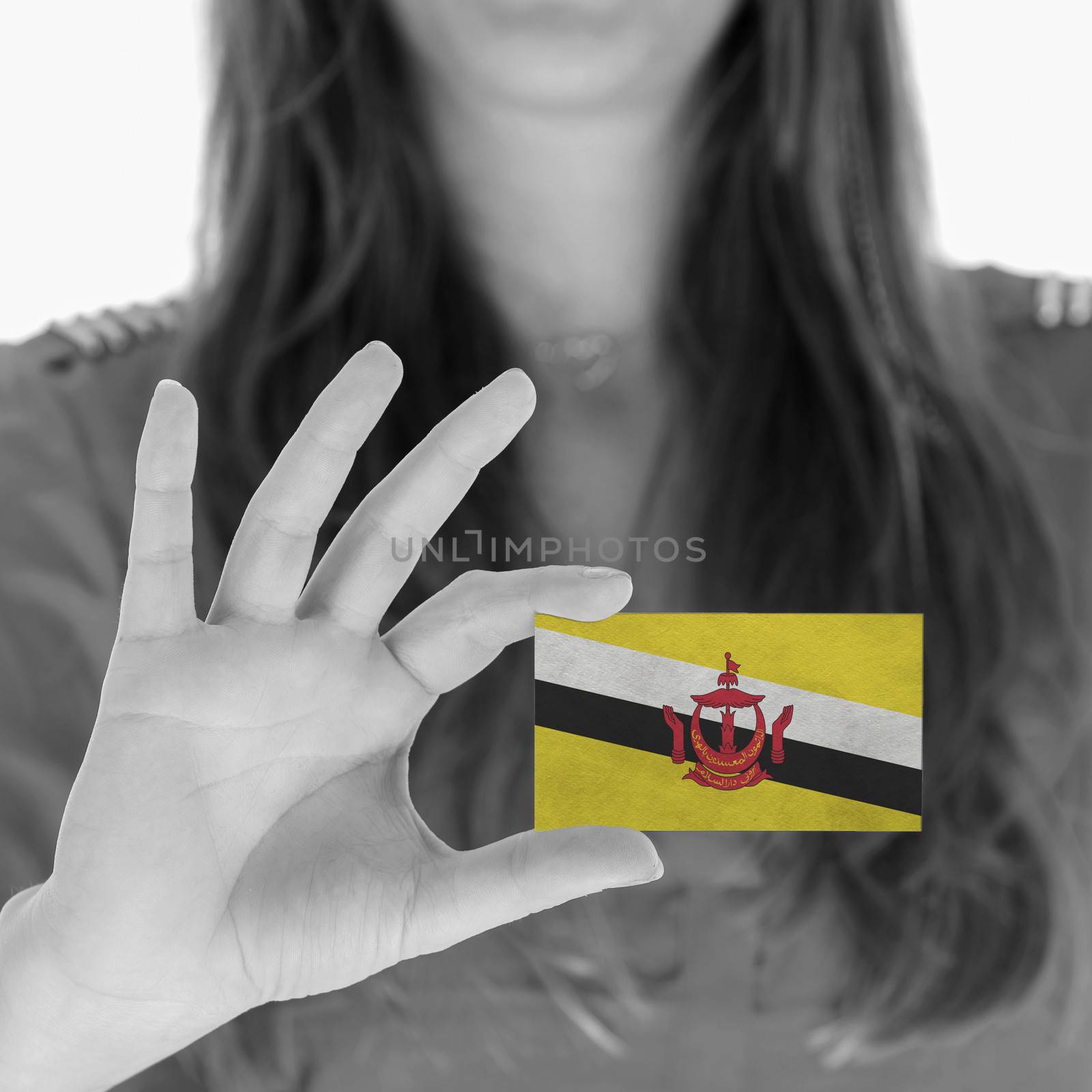 Woman showing a business card, flag of Brunei
