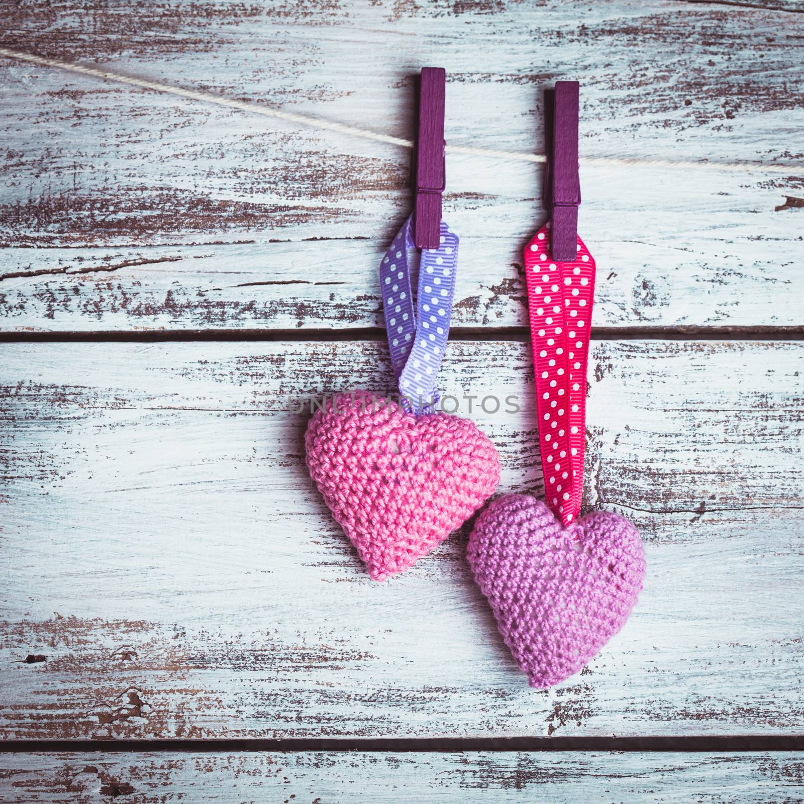 Crochet valentine hearts handing on the rope. Valentine's day greeting card. Love concept