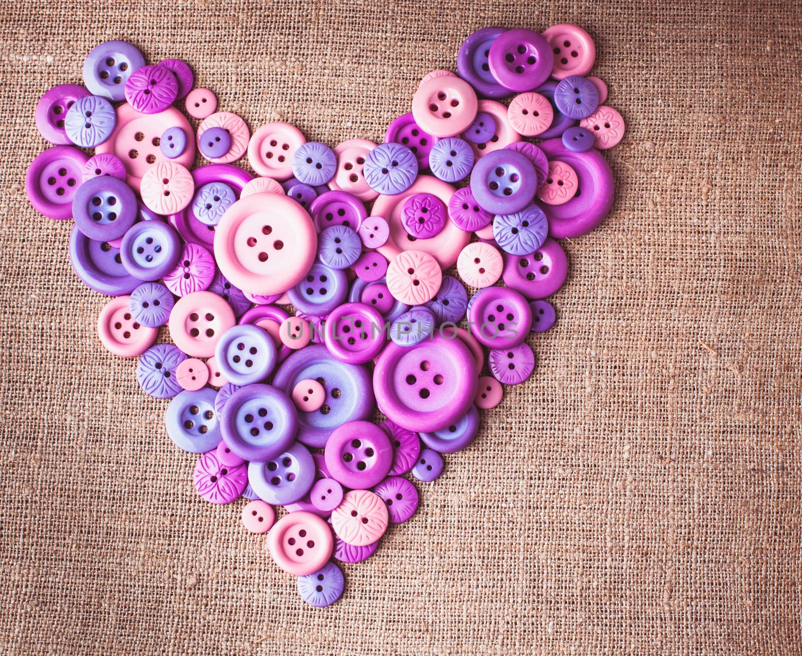 Heart shape from buttons over canvas textile