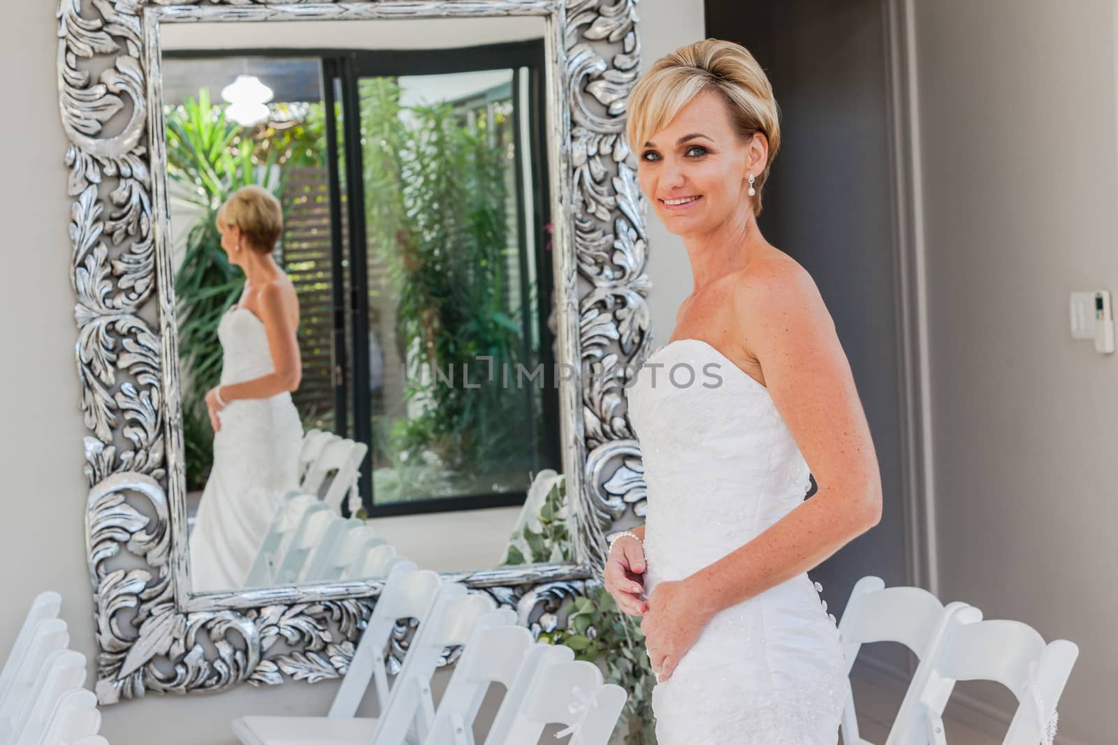 Bride with happy smiles at home ready for wedding ceremony.