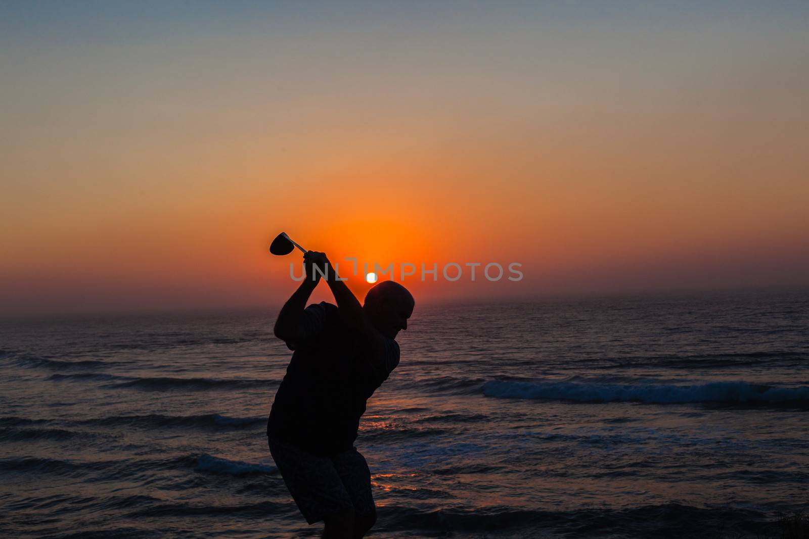 Golf player swing dawn patrol sunrise links golf course.