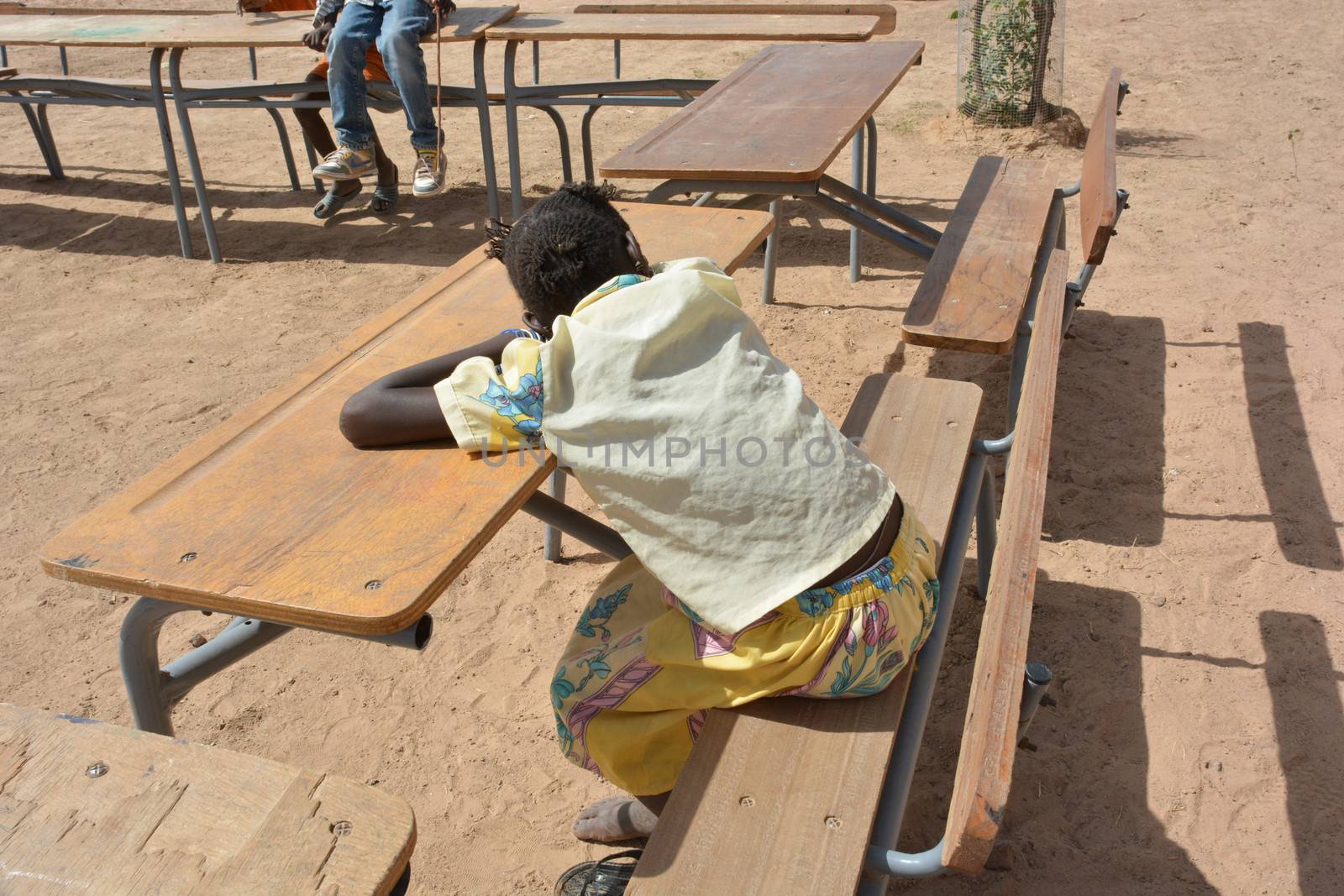 African child slip on the bench of school