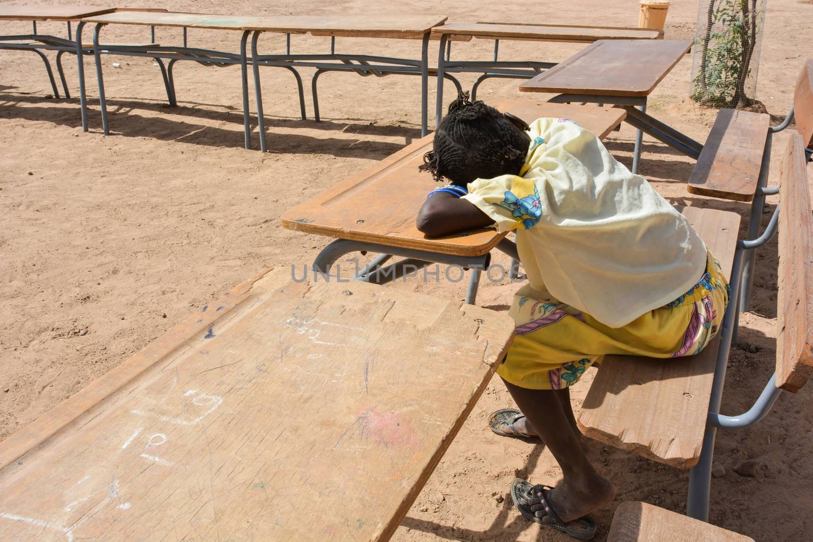 African child slip on the bench of school