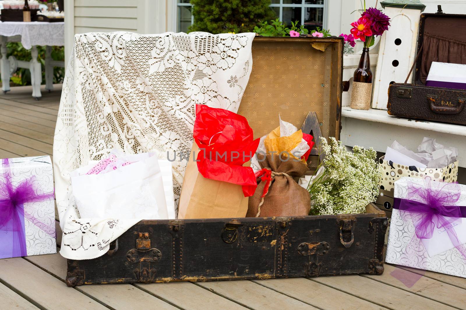 Wedding ceremony gifts are placed in this suitcase outdoors at a summer wedding with the theme rustic country chic.