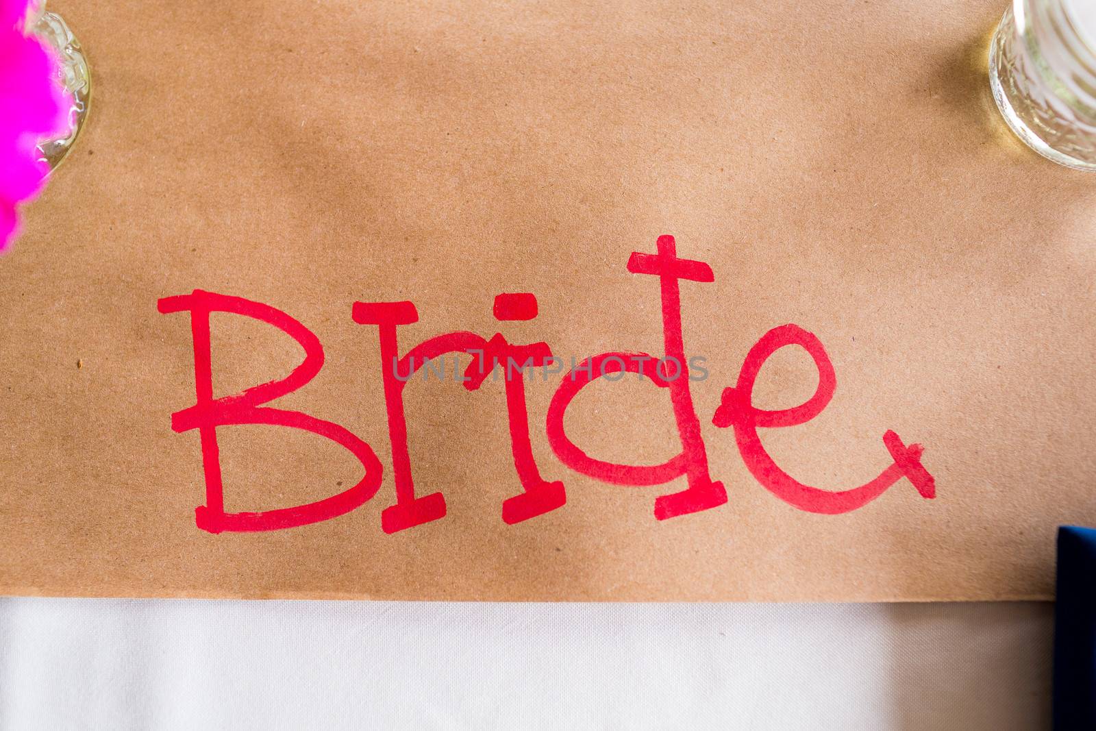 A table sign says bride to reserve her spot at a wedding reception.