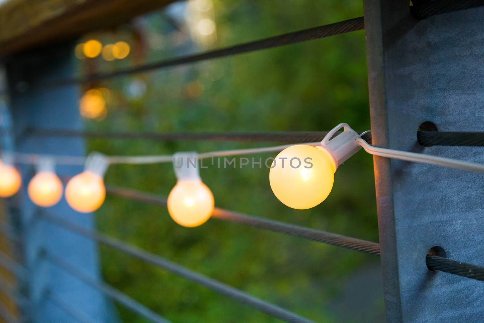 Lights are strung up and hung for this outdoor night time wedding reception.