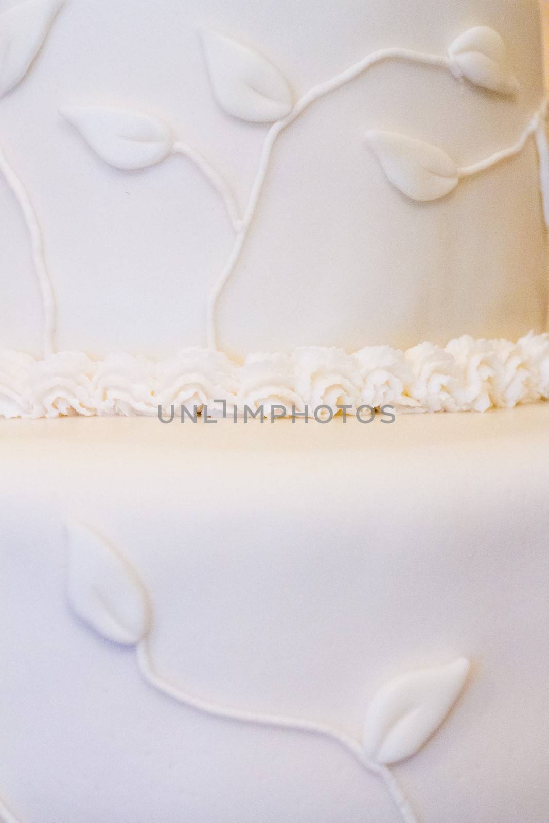 A beautiful wedding cake is set up at the reception for a bride and groom.