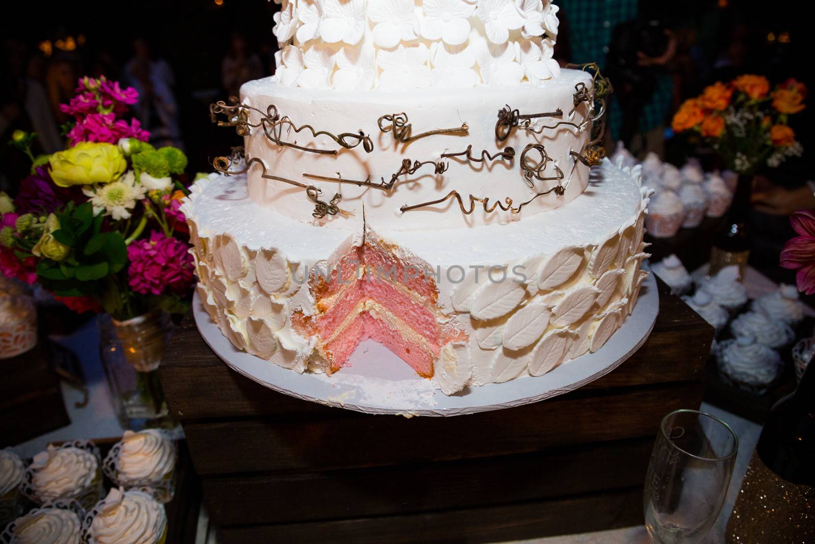 A wedding cake has a missing slice after the bride and groom cut the cake at their reception.