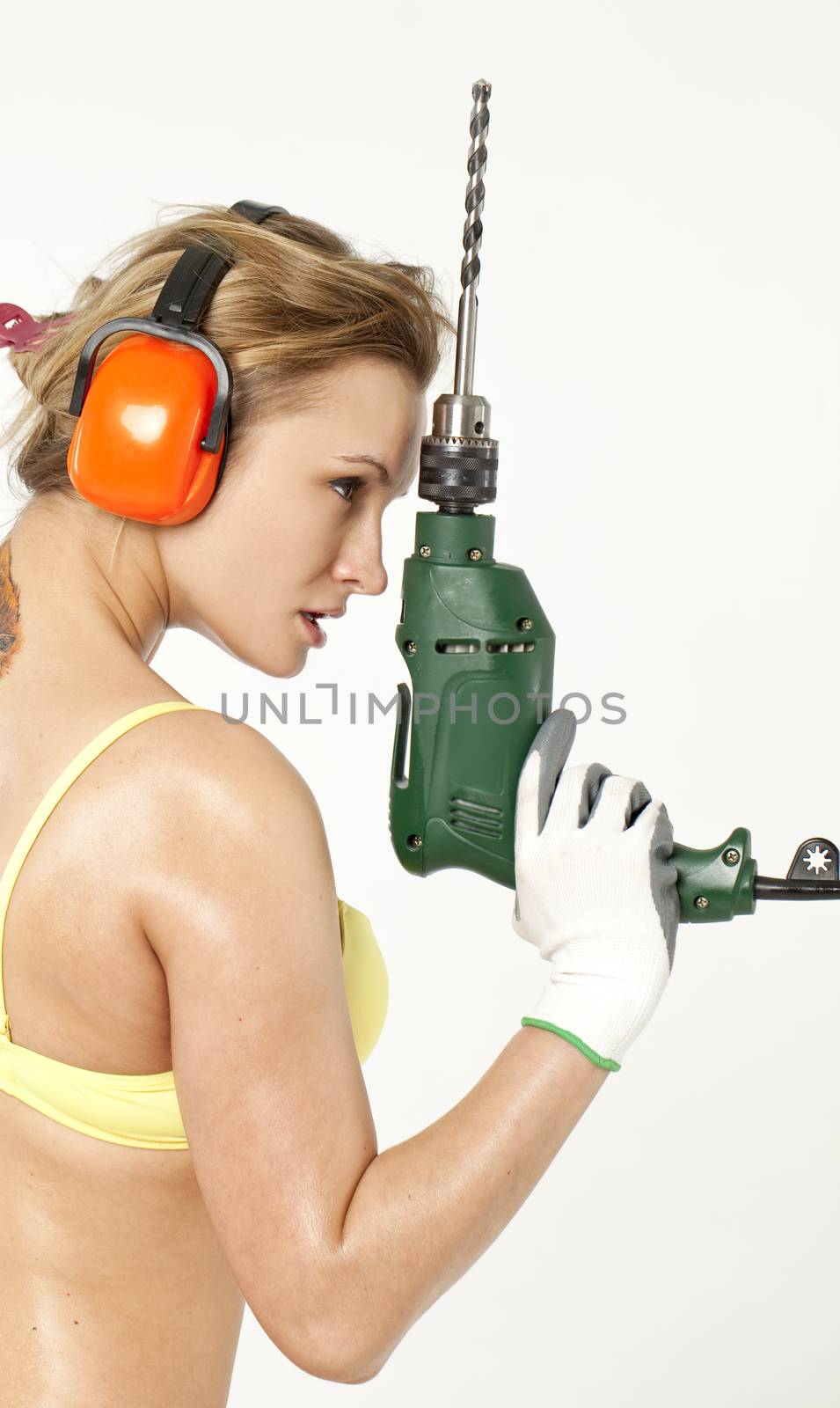 Young sexy woman holding a construction drill