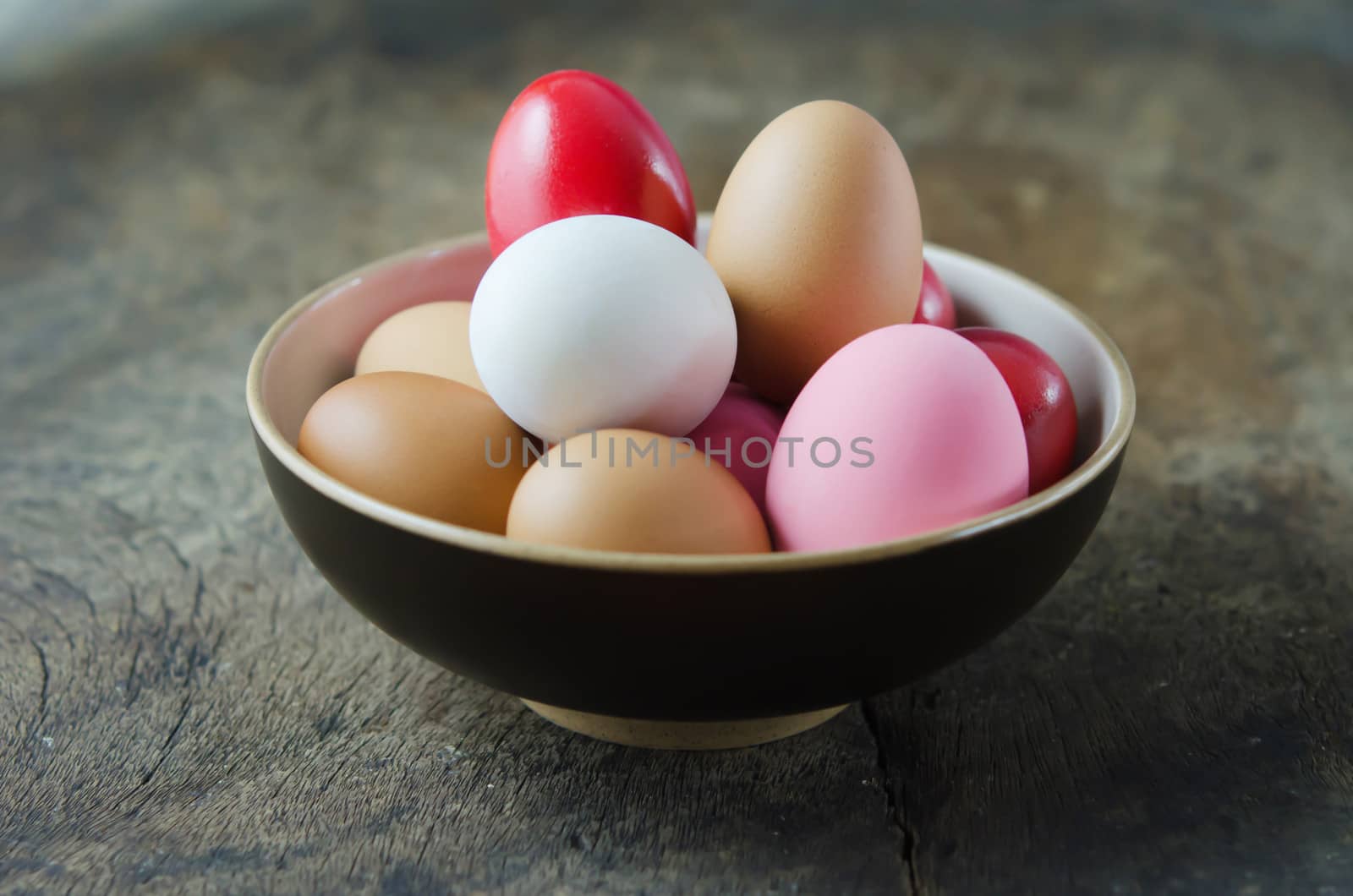 colorful of  eggs in  bowl on wooden table