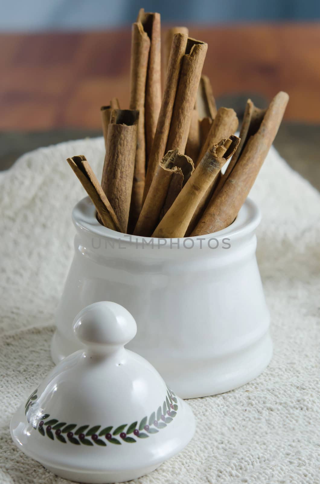 close up white  bowl with cinnamon sticks on  sackcloth