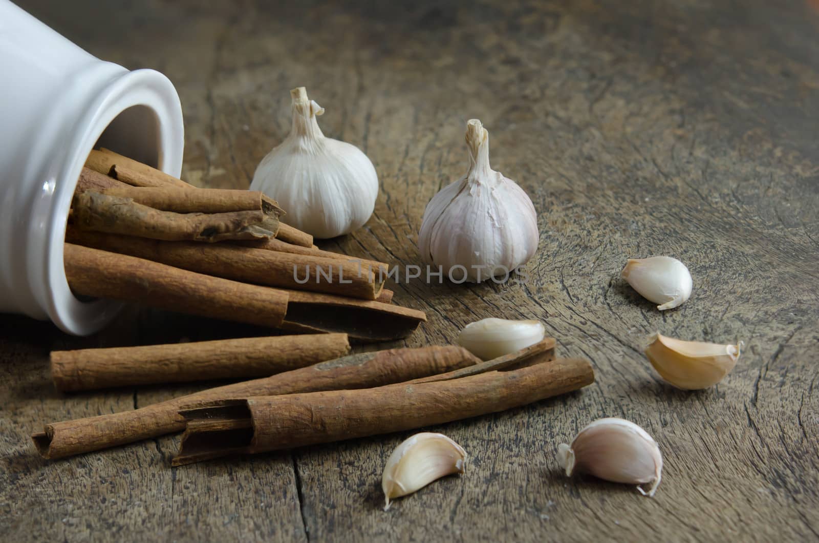 close up  cinnamon sticks and garlic on wooden background