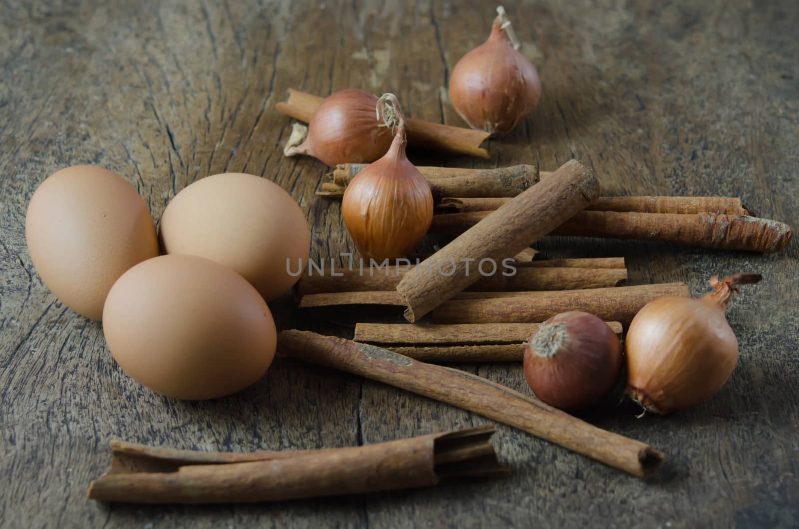 eggs, cinnamon sticks and onion  on wooden background