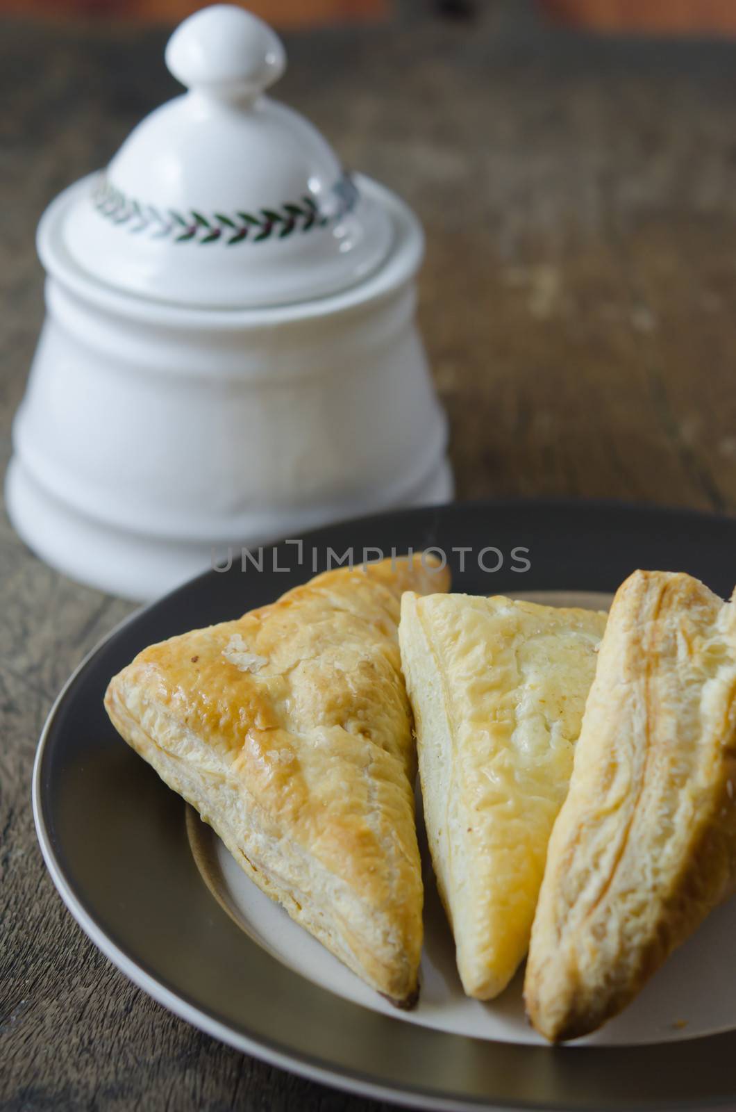 Puff pastry on the plate over wooden background