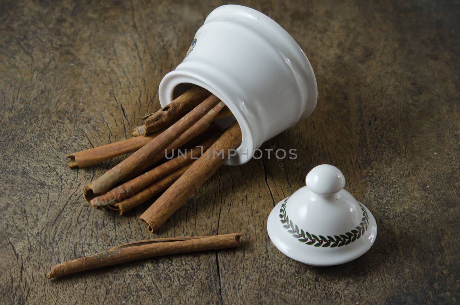 White  bowl with cinnamon sticks on  wooden background