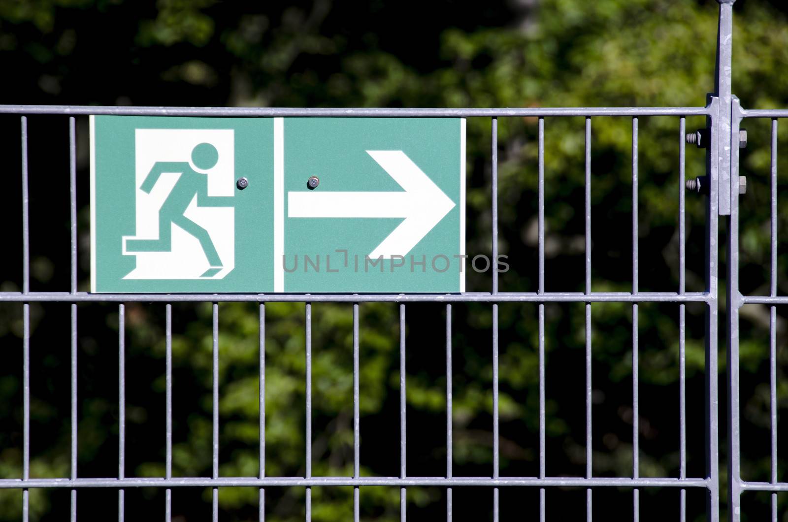 Green escape route sign on a metal fence