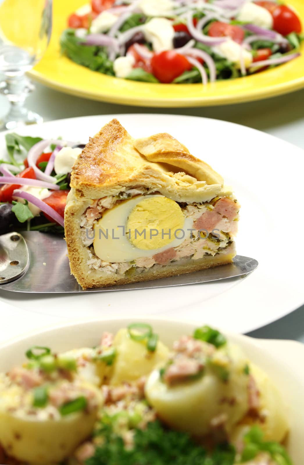 Delicious slice of baked ham and egg pie with salad ready to serve.