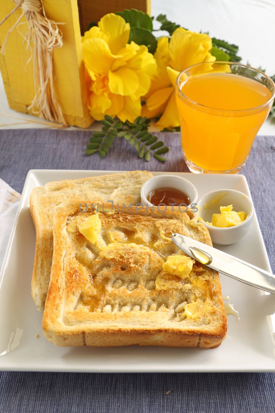 Slice of toast with Good Morning carved into it with butter and honey.