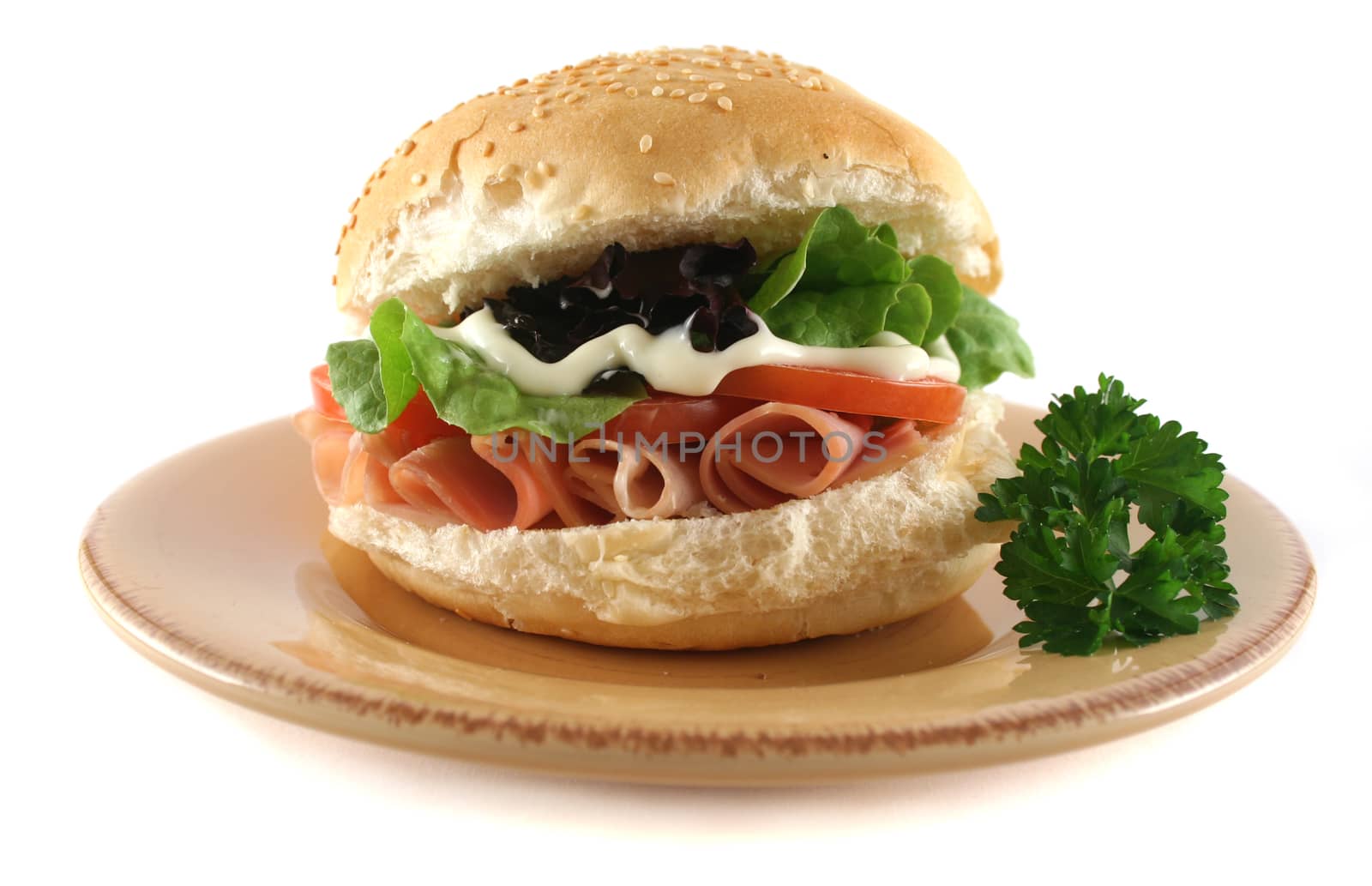 Freshly prepared ham and salad roll with mayo.