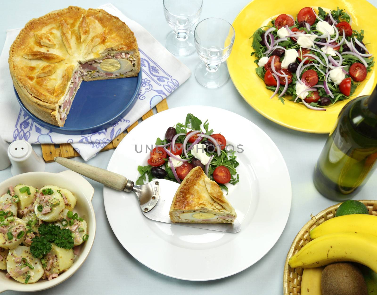 Delicious baked ham and egg pie with potato and salad ready to serve.