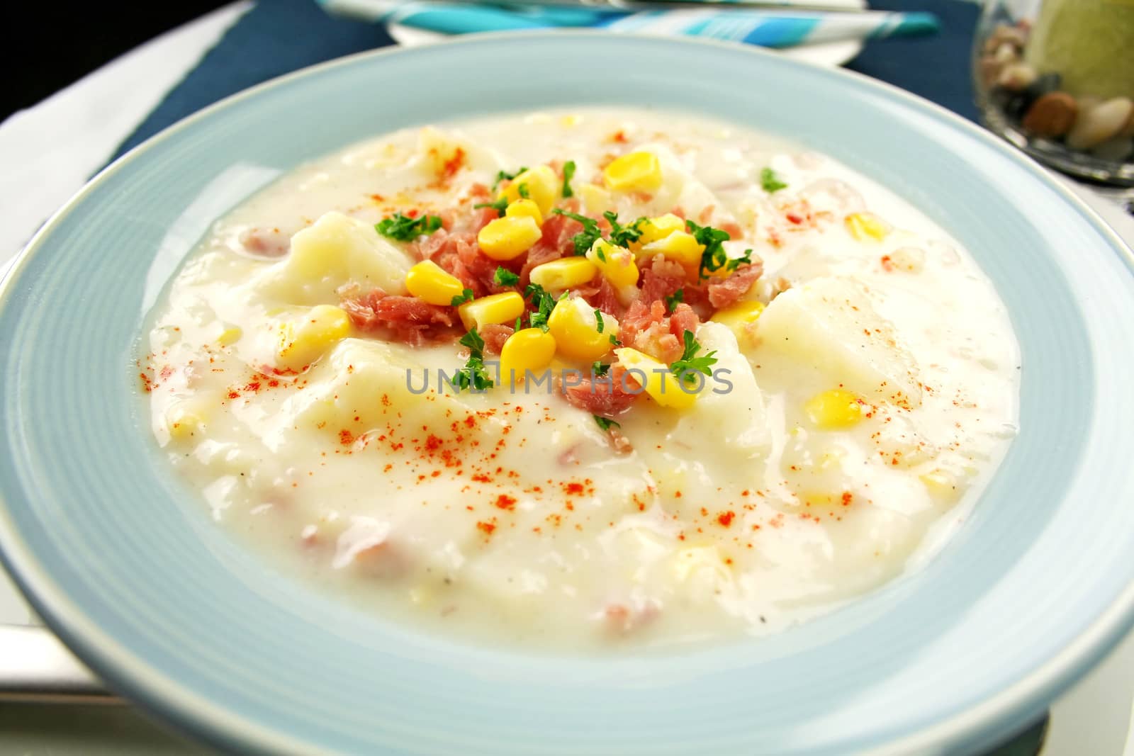 Freshly prepared ham corn and potato chowder with paprika ready to serve.