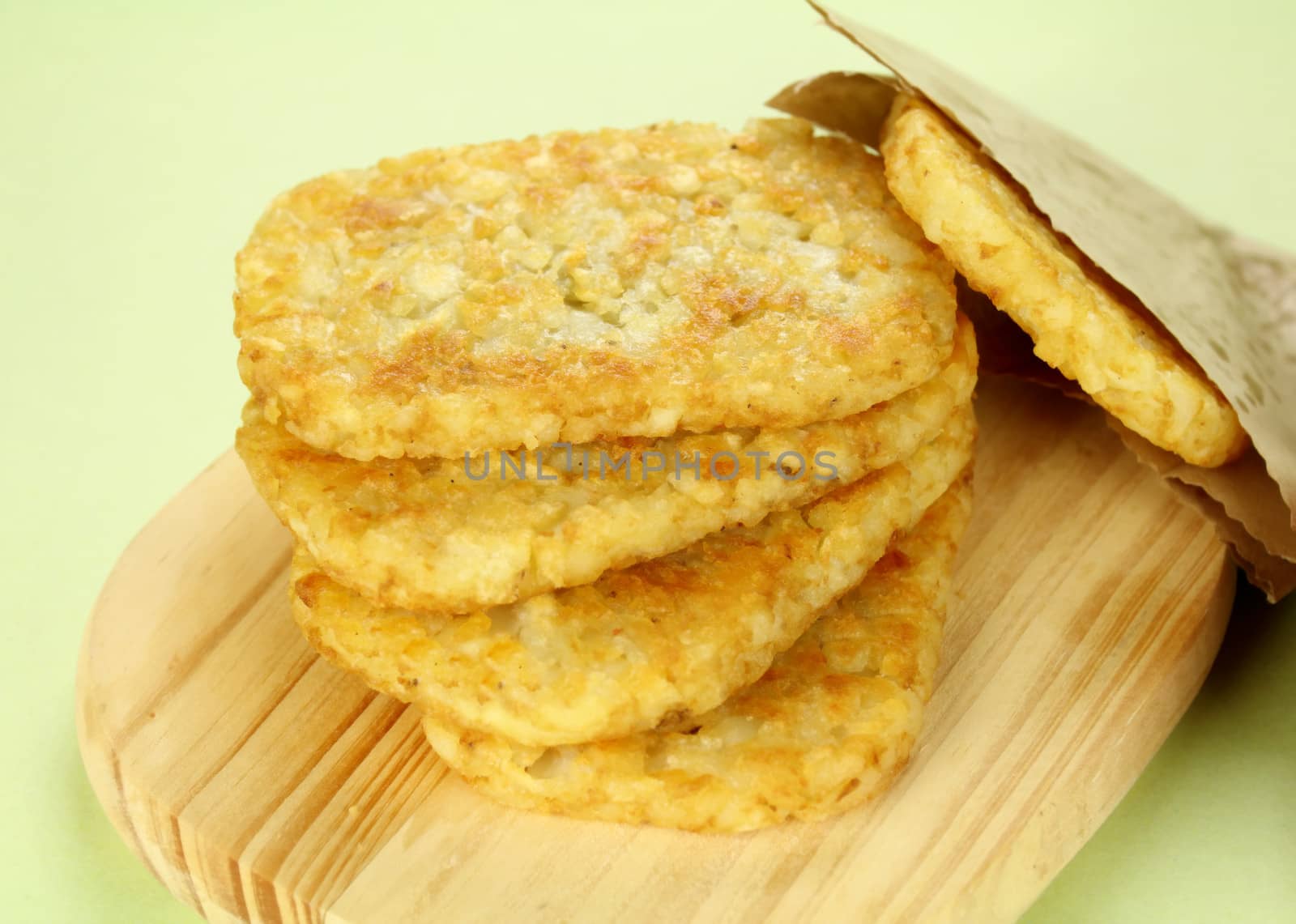 Stack of fried hash browns on a board ready to serve.