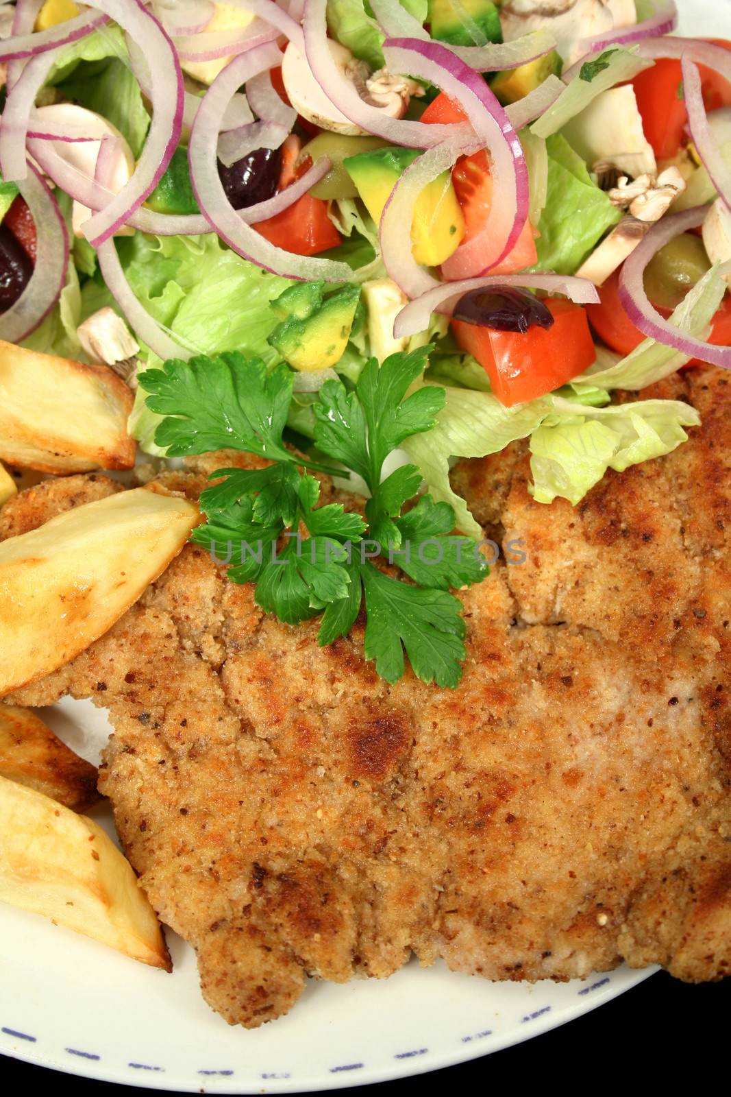 Hearty homemade chicken schnitzel with salad and chips.