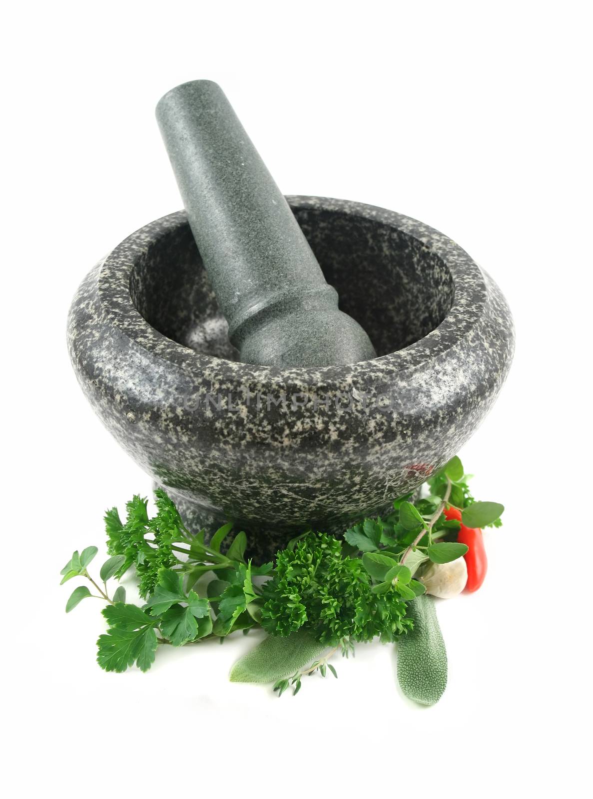 Fresh herbs with garlic and chilli ready to crush in a mortar and pestle.