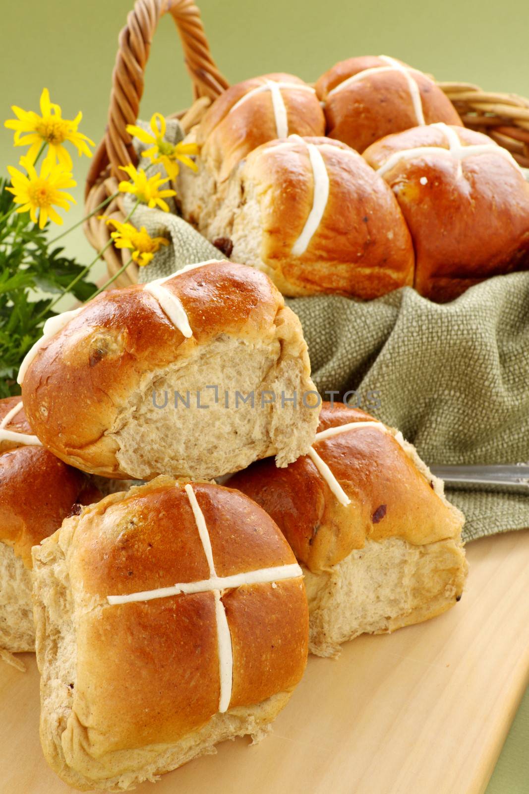 Hot cross buns in a basket with daisies ready to serve.