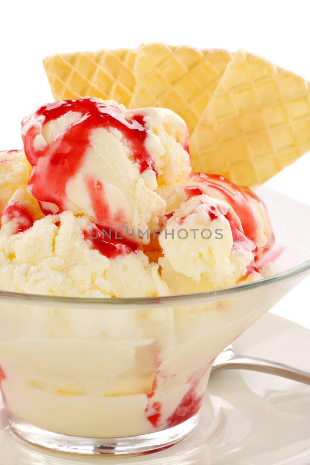 Vanilla ice cream with strawberry topping and golden wafers.
