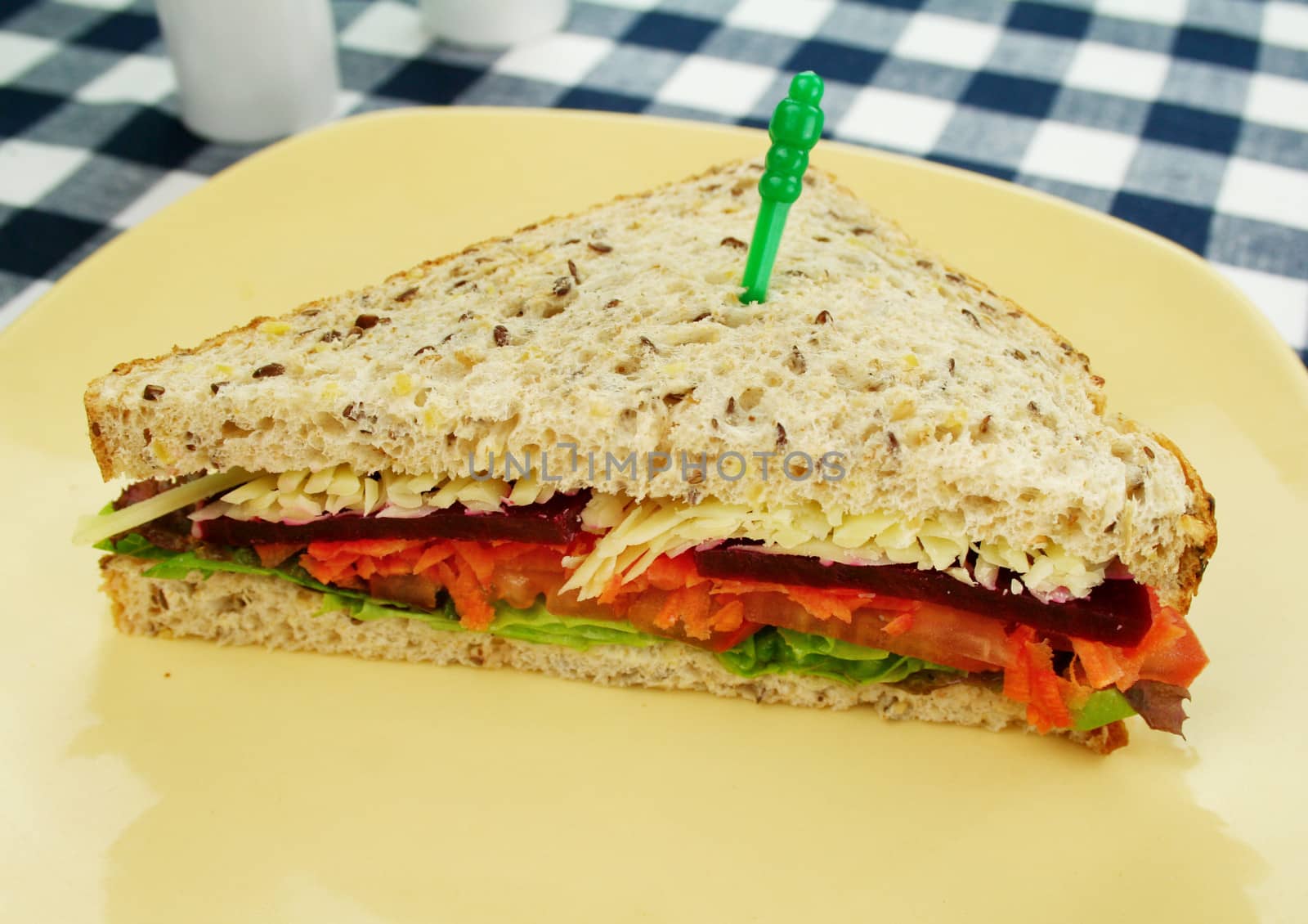 Large freshly made salad sandwich cut in half ready to serve.