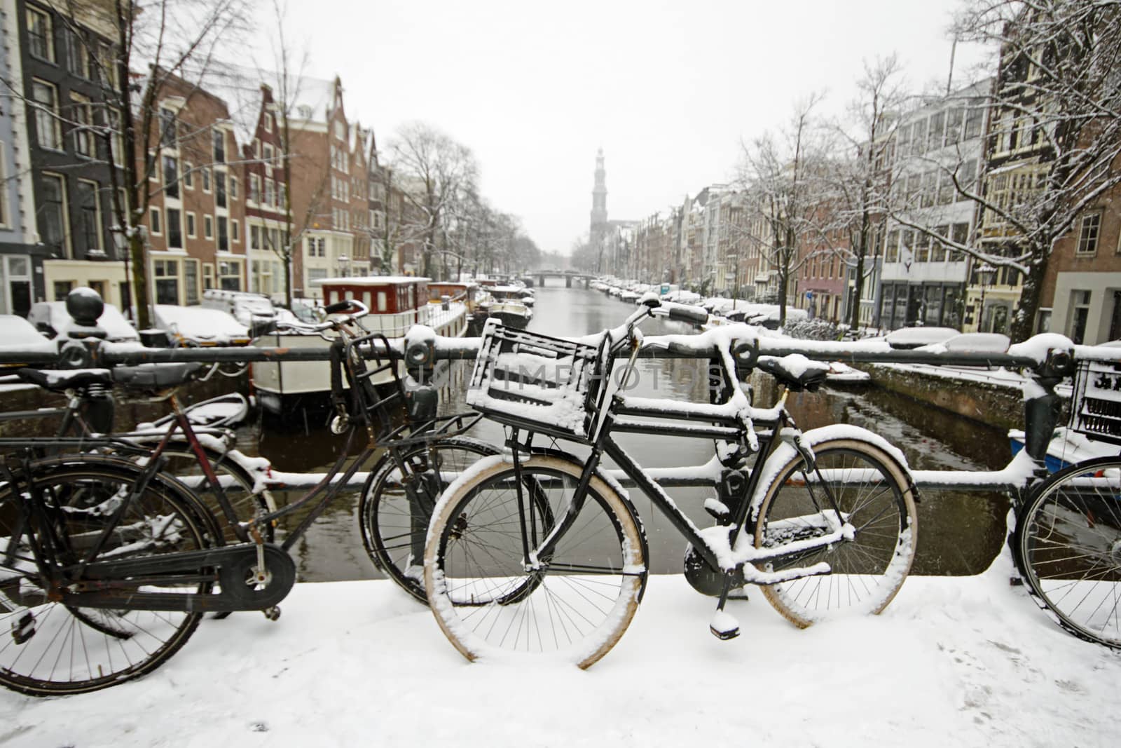 Amsterdam covered with snow with the Westerkerk in winter in the Netherlands