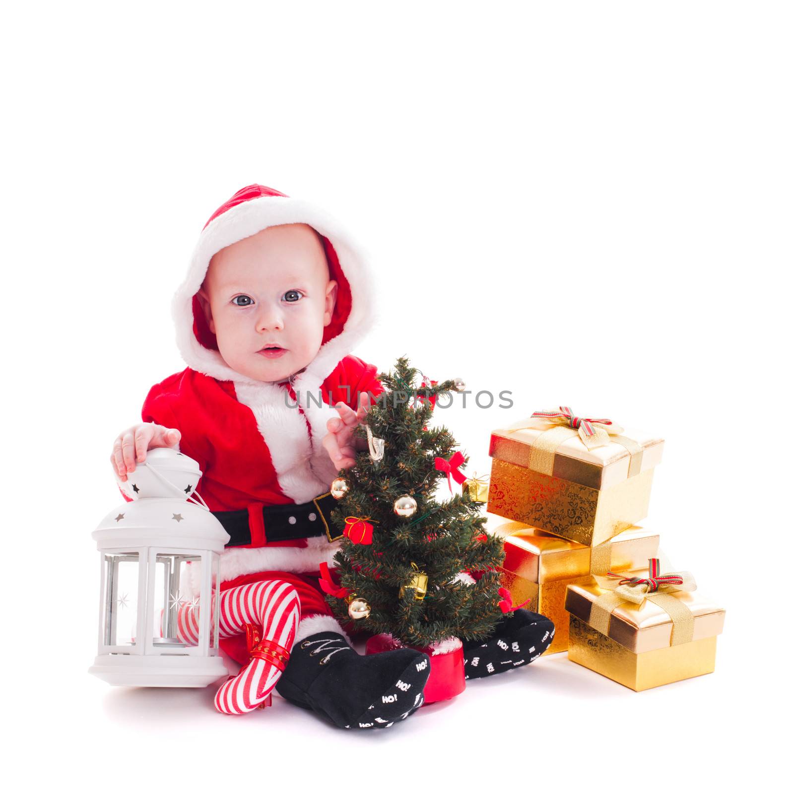 Little Santa boy with lantern, christmas tree and gift boxes isolated on white
