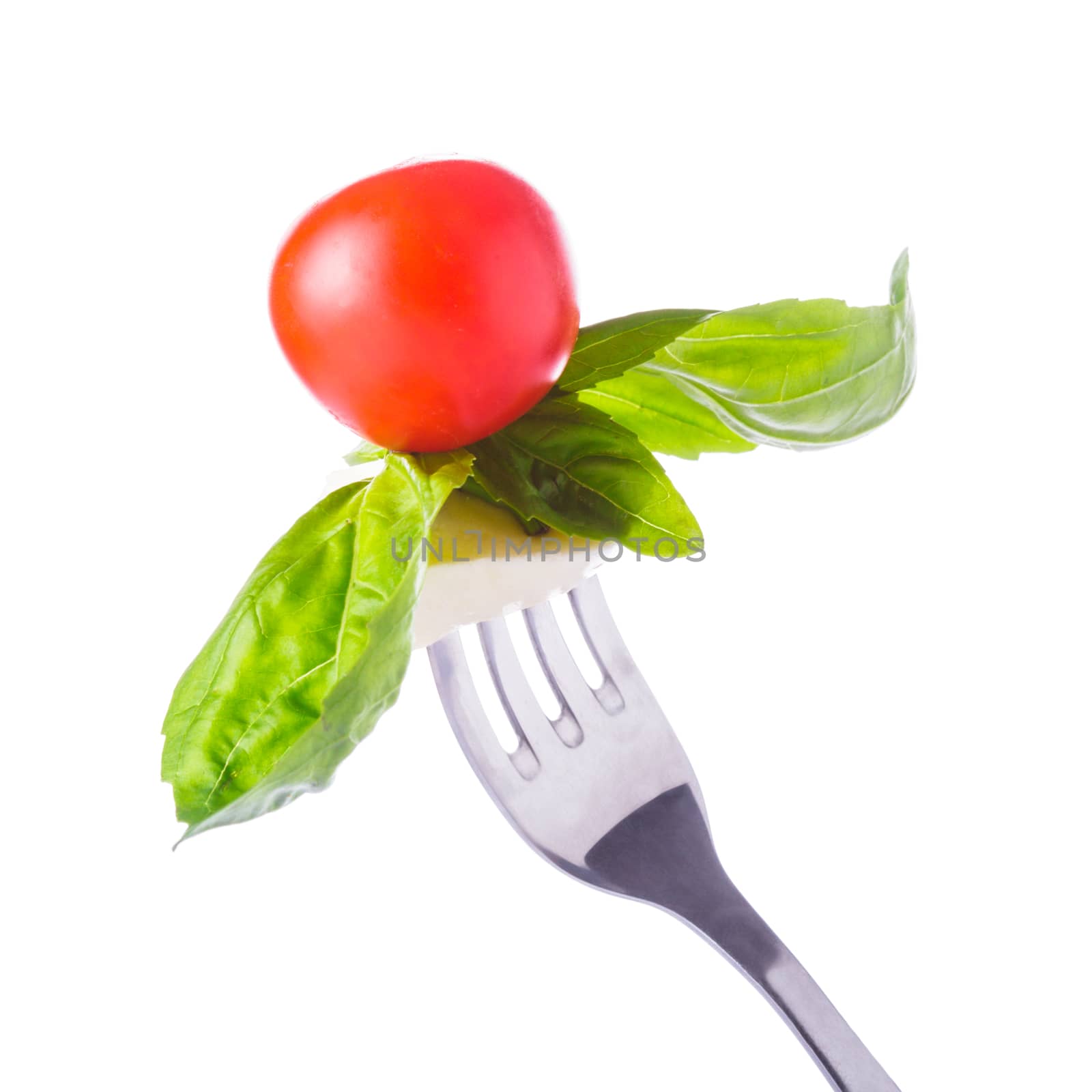 Caprese salad ingredients on the fork isolated on white