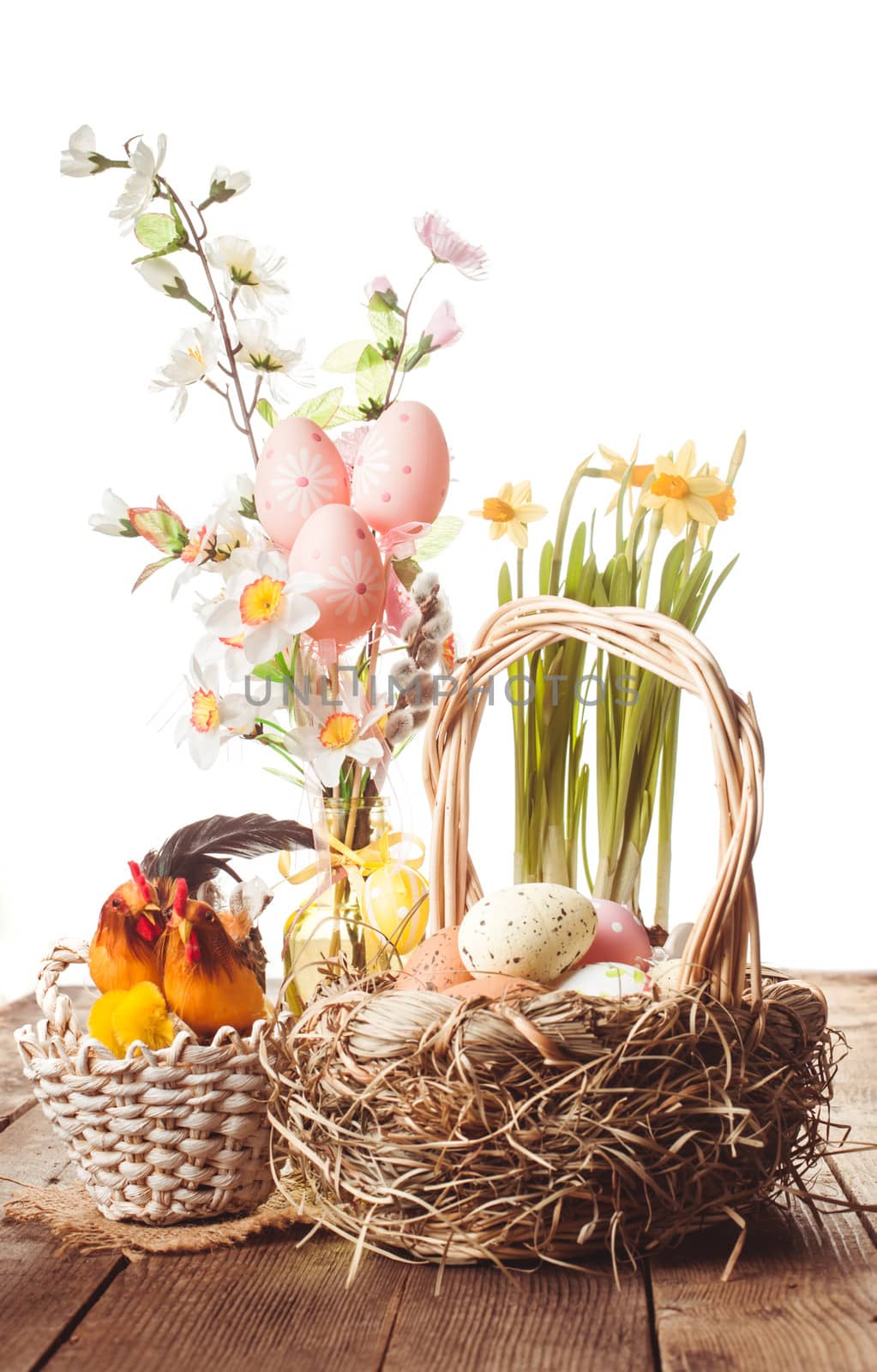 Pink and yellow eggs in basket, Easter decorations on white background