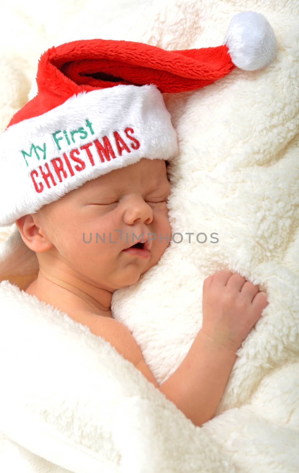 Baby's first Christmas - a newborn sleeping in a santa hat