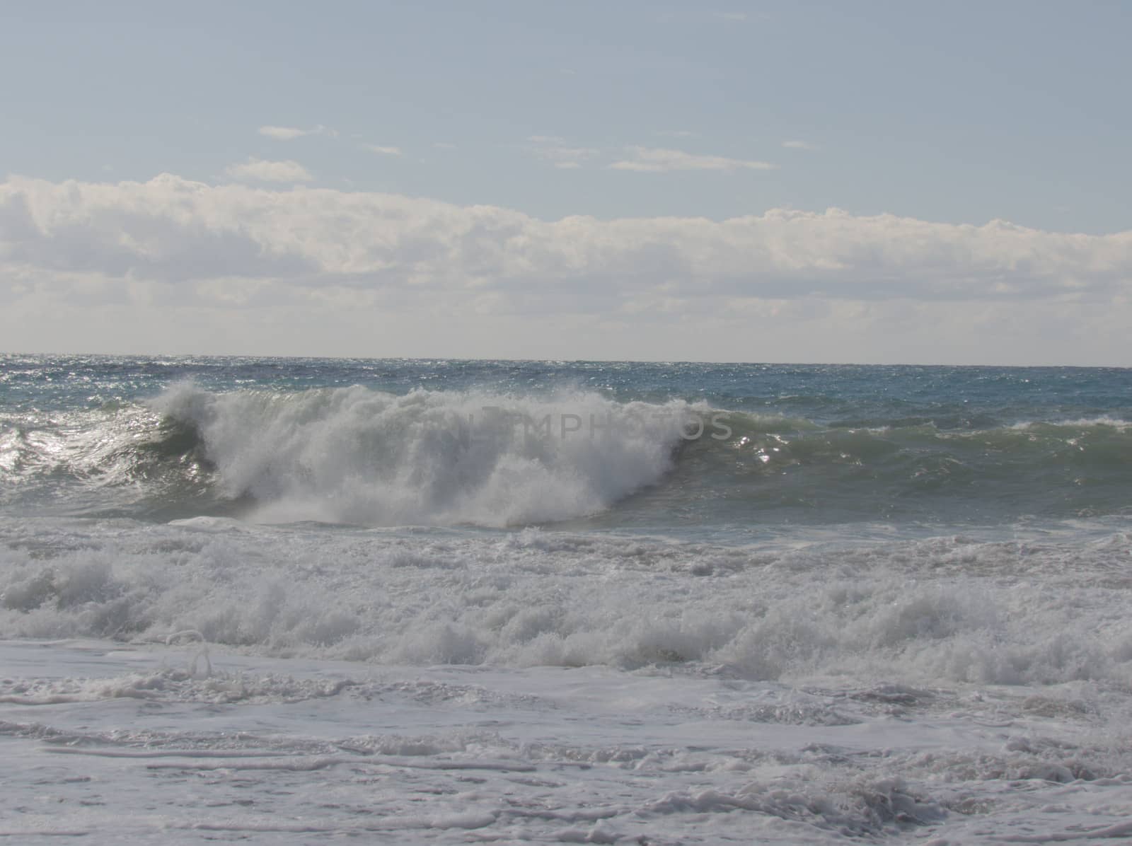 Beautiful wave rolls of white foam on the shore of the Mediterranean