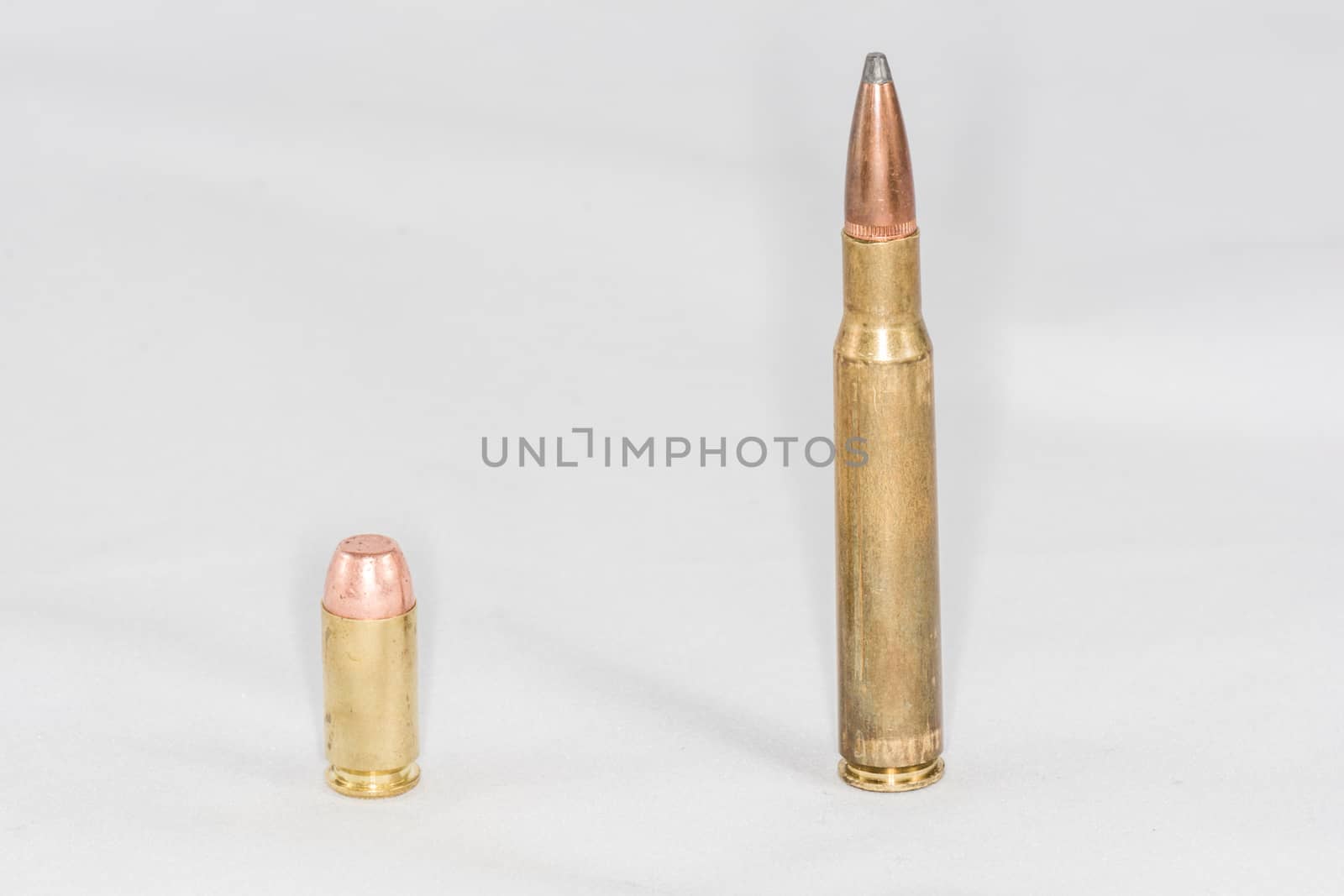 Hand gun and rifle bullets on white background with detail