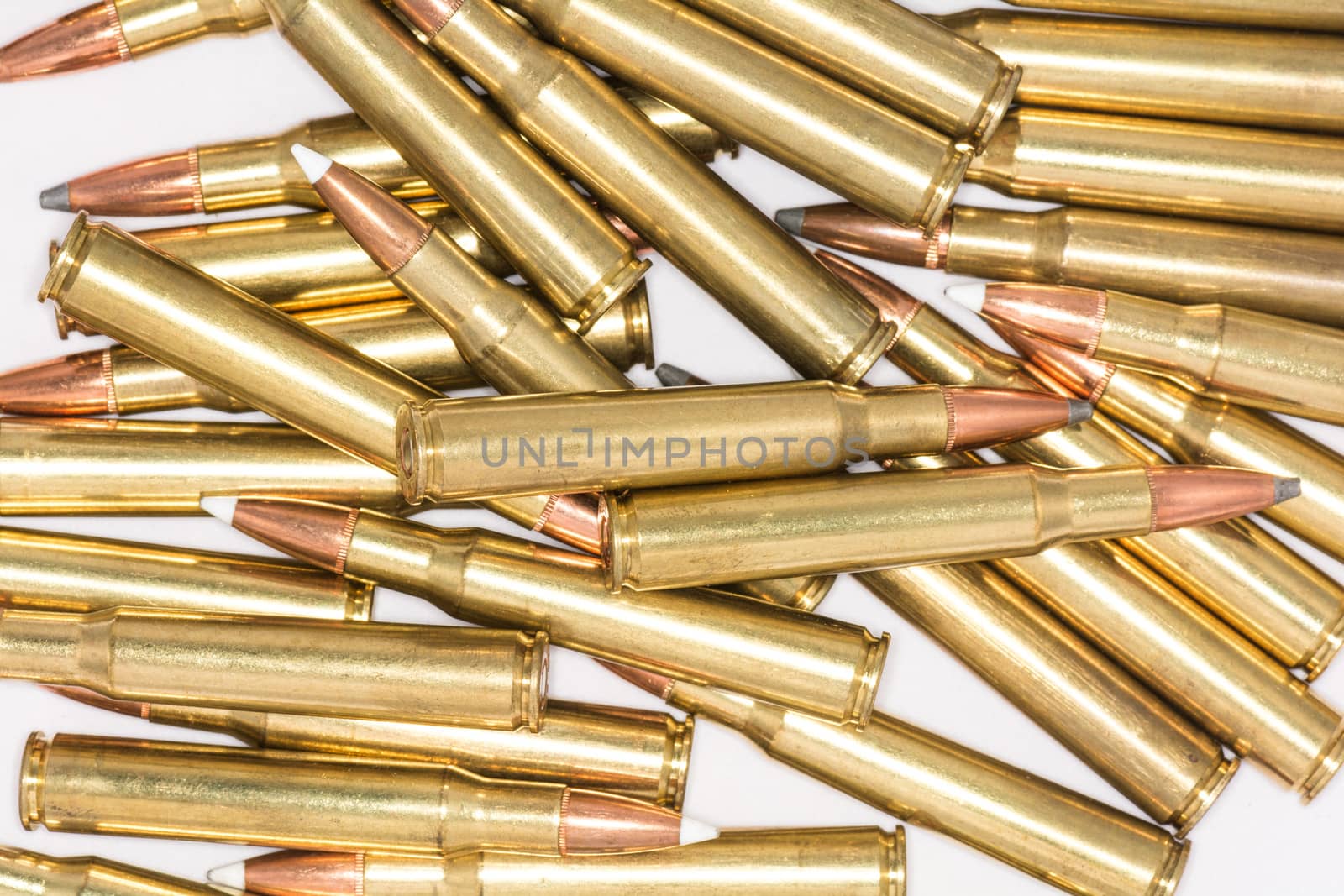 Pile of loaded rifle bullets isolated with white background with details