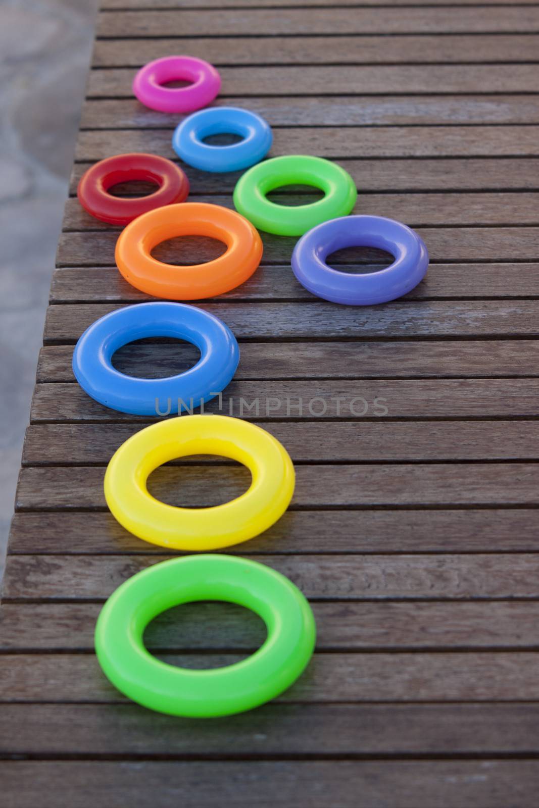 Close up of a row of childrens stacking rings in bright colors. Focus on the middle ring