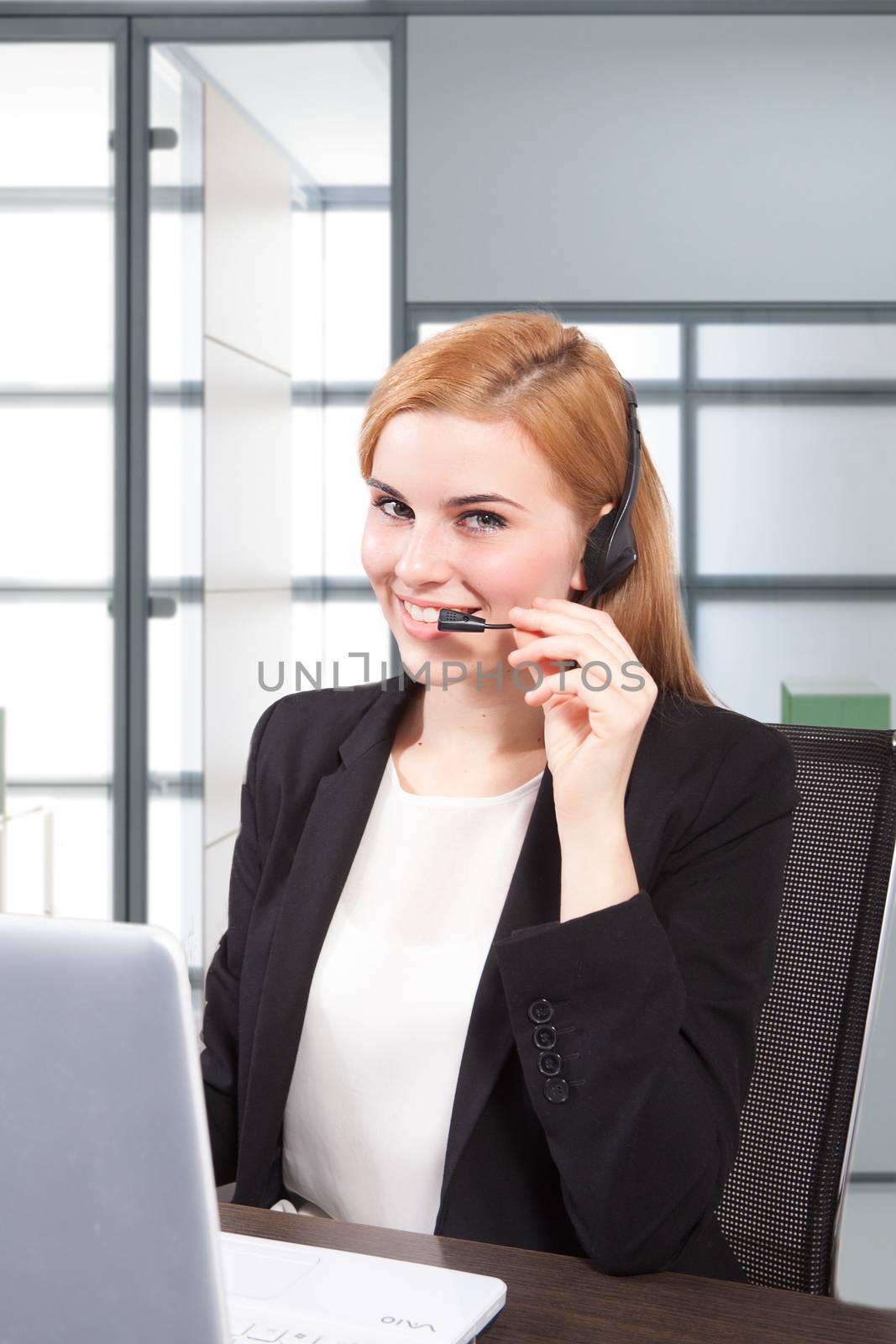 Businesswoman sit at desk and talking on headset 