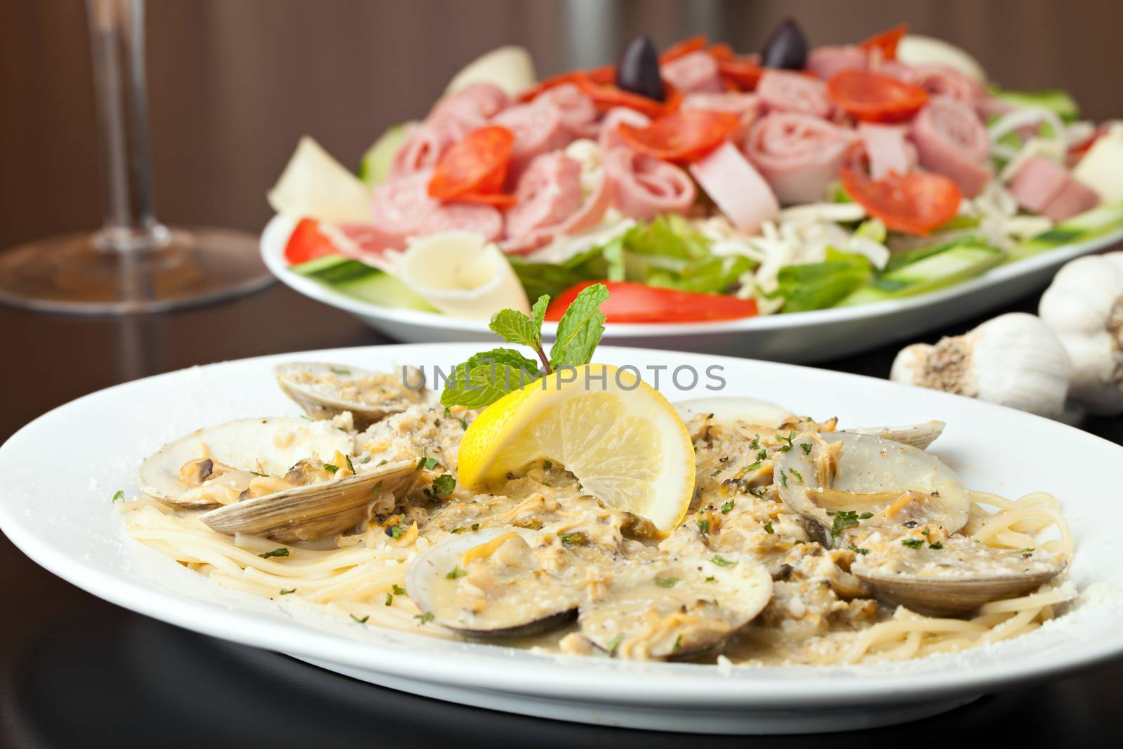 Italian pasta dish with fresh clams over pasta with herbs and cheese.  Shallow depth of field.