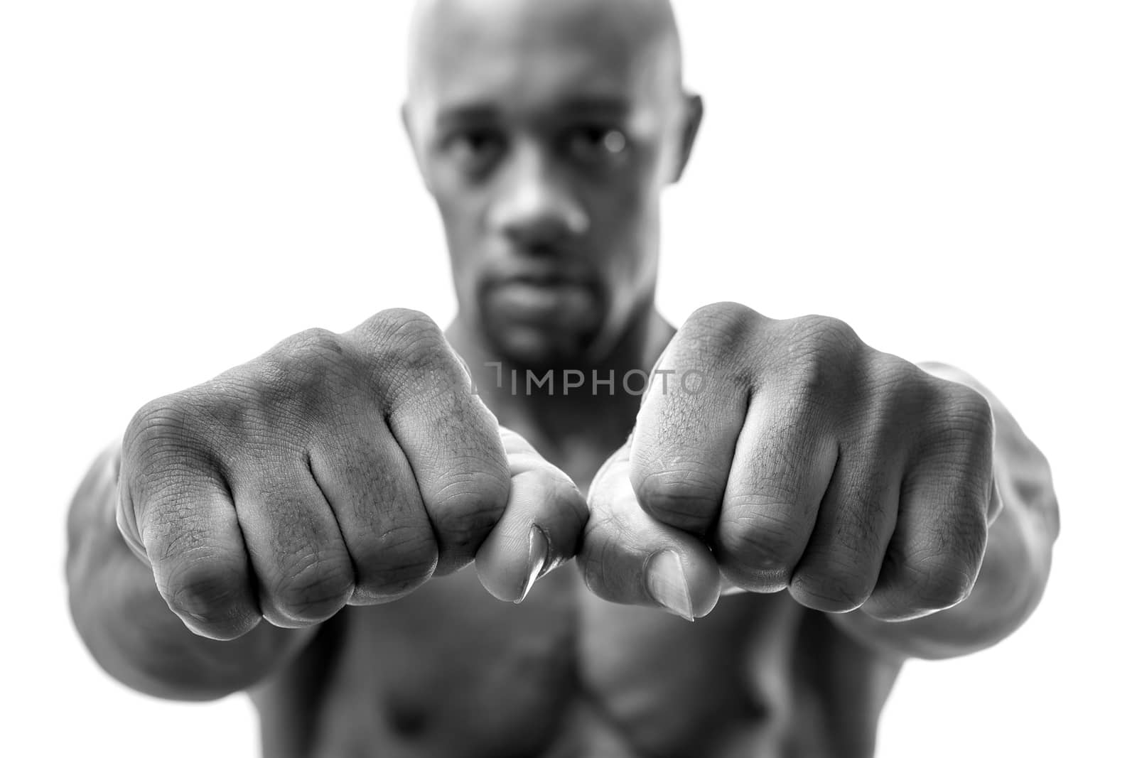 Muscular man of African descent isolated over a white background showing a closeup of his fists and fingers.  Shallow depth of field.