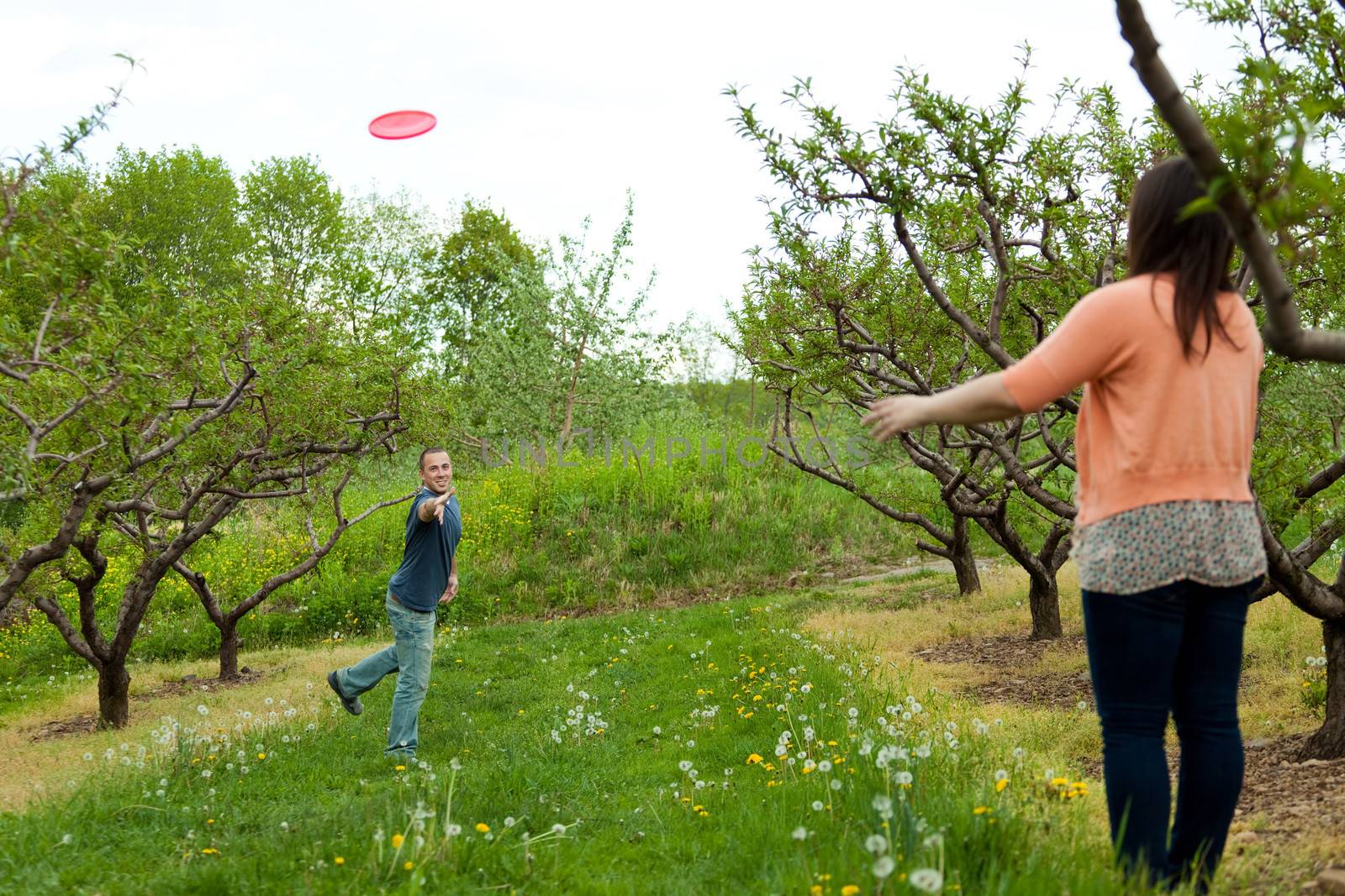 A couple plays with a frisbee together outdoors.